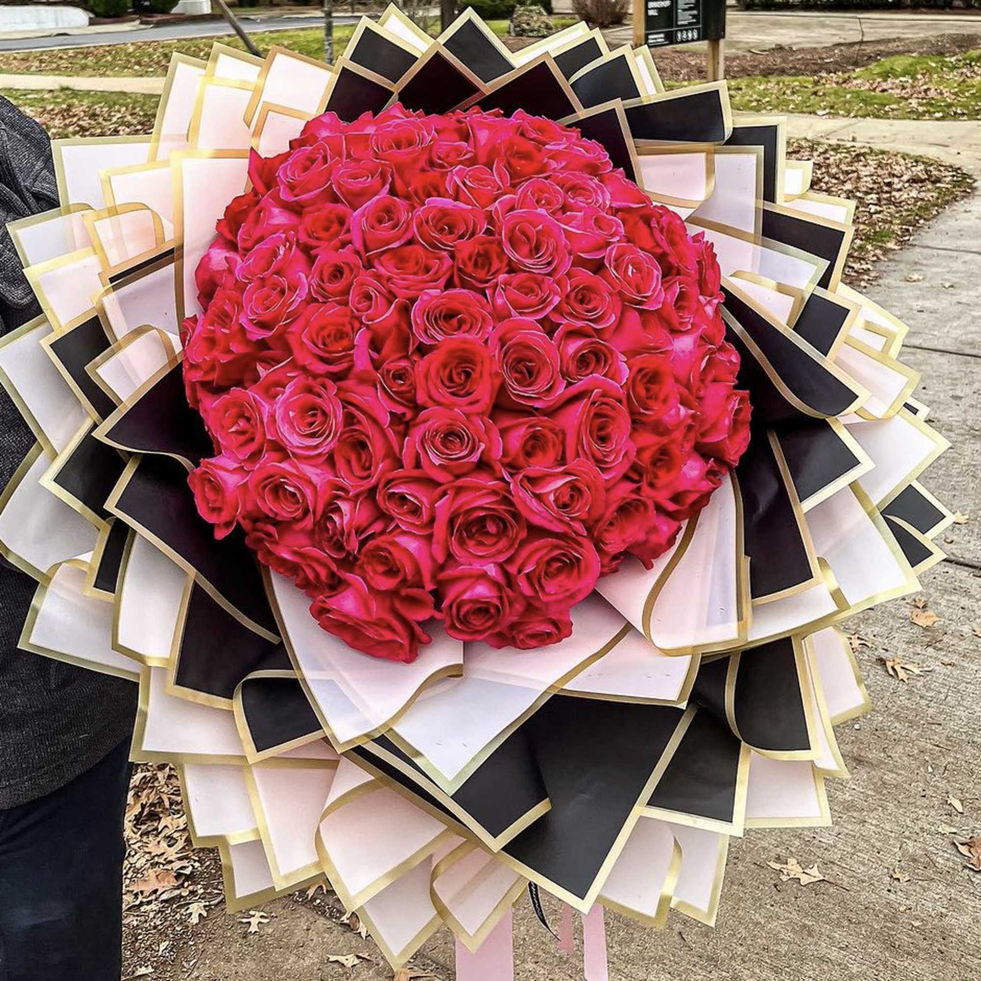 Large bouquet of hot pink roses with black and white wrapping