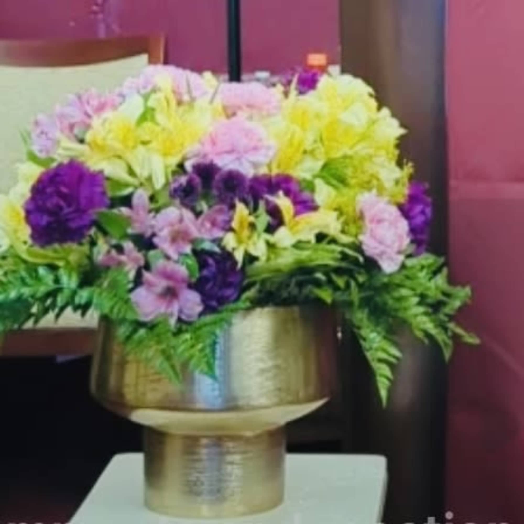 Colorful bouquet in a gold vase on a chair