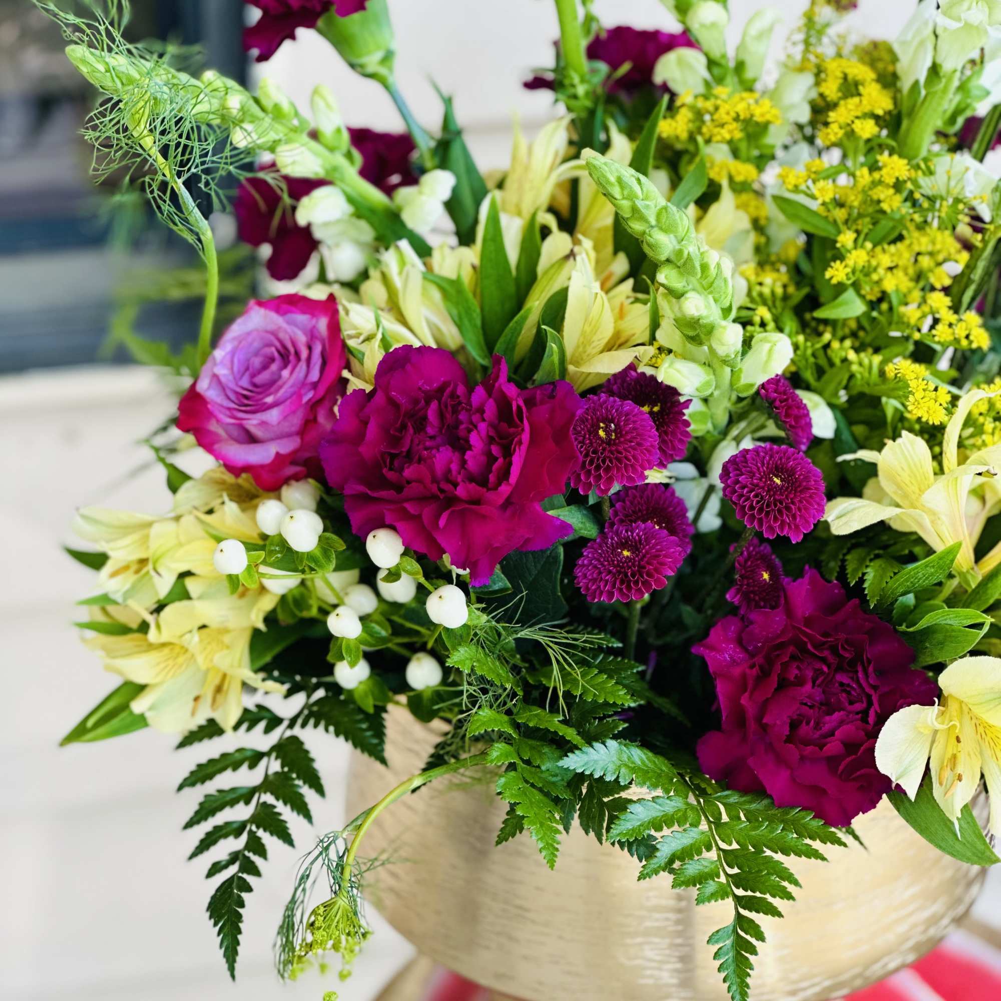 Bouquet of magenta and cream flowers in a gold wrap