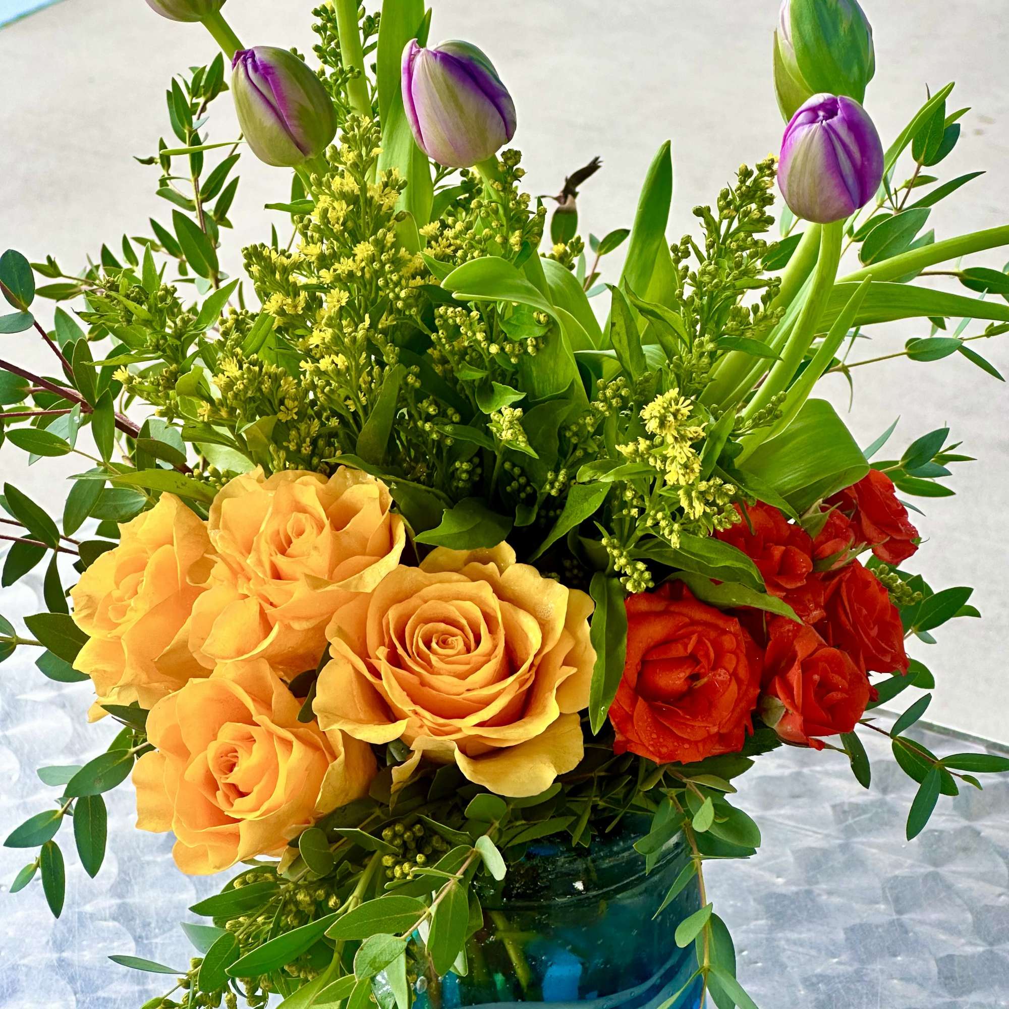 Bouquet of yellow and red roses with purple tulips in a blue vase, photo 2 of 2