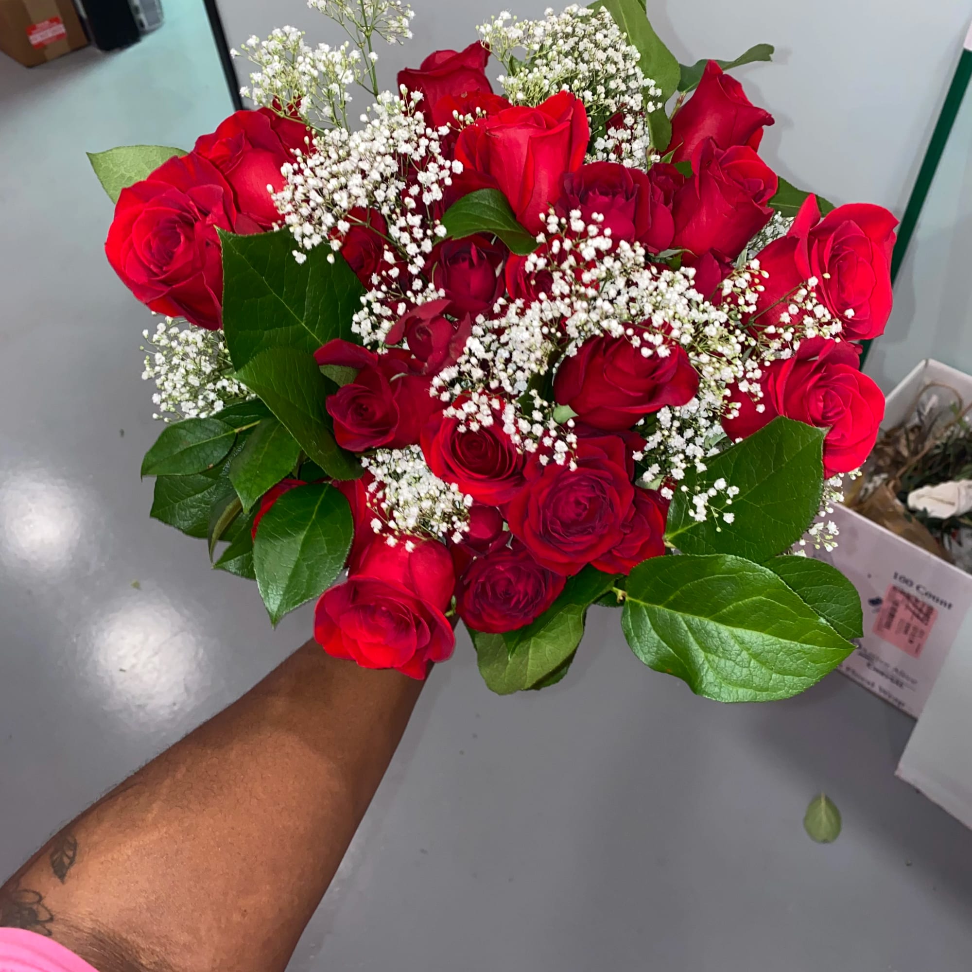 Handheld bouquet of red roses with white baby's breath