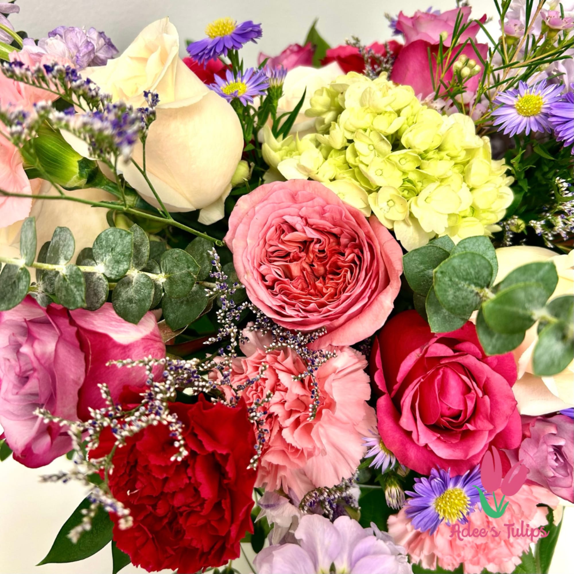 Mixed bouquet with pink and cream roses, hydrangea, carnations, and purple daisies
