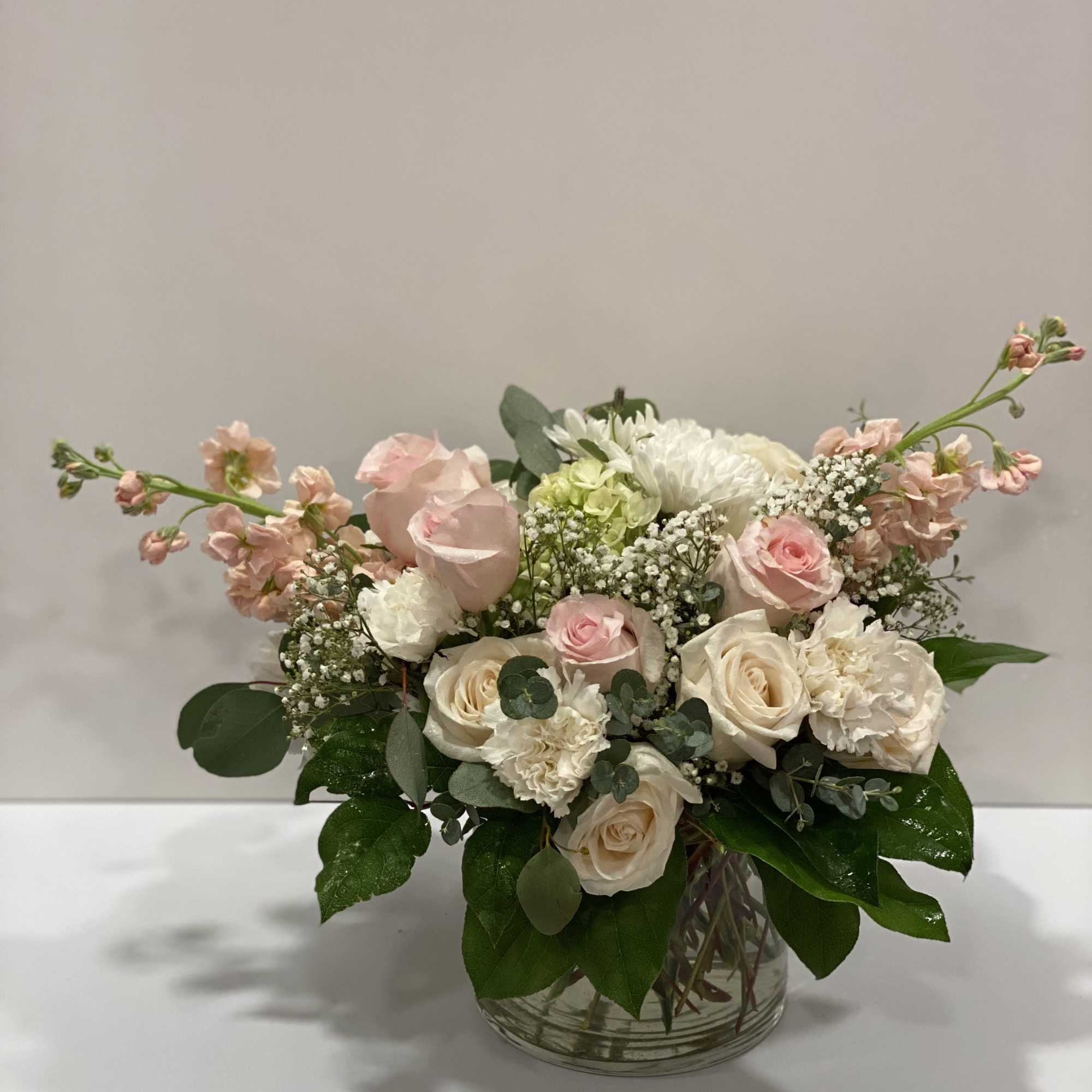 Blush and white flower arrangement in a clear glass vase
