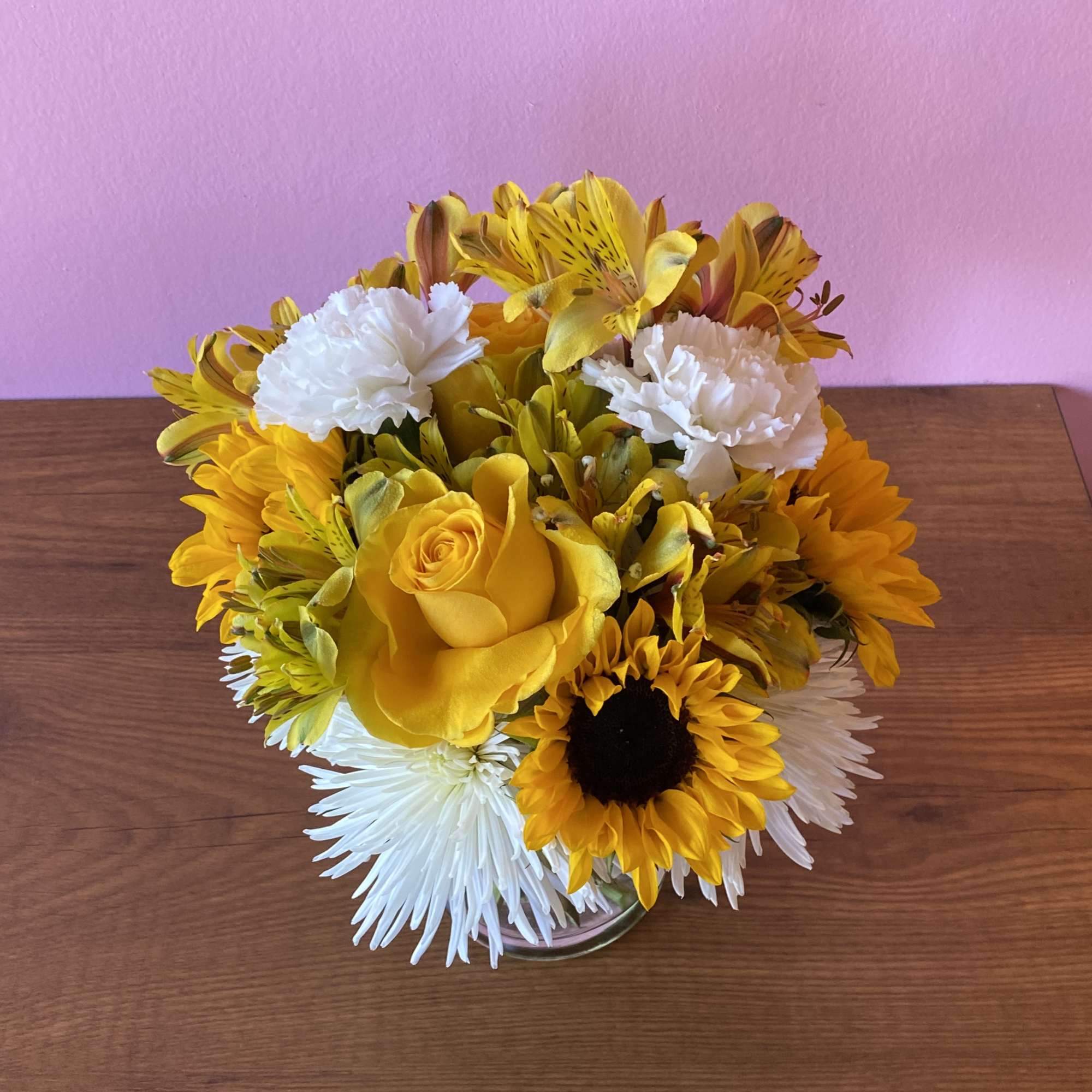 Yellow and white flower arrangement in a clear glass vase