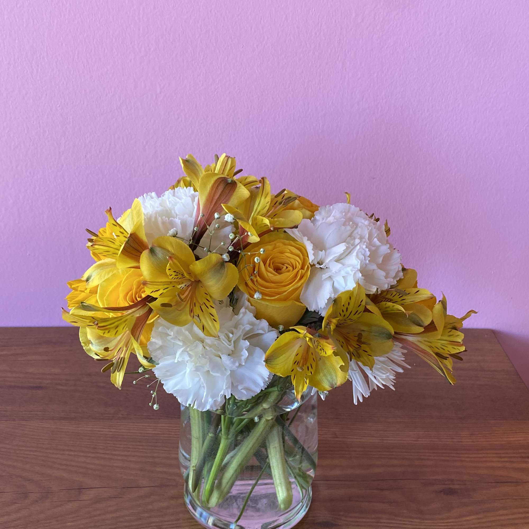 Yellow and white flower bouquet in a clear glass vase