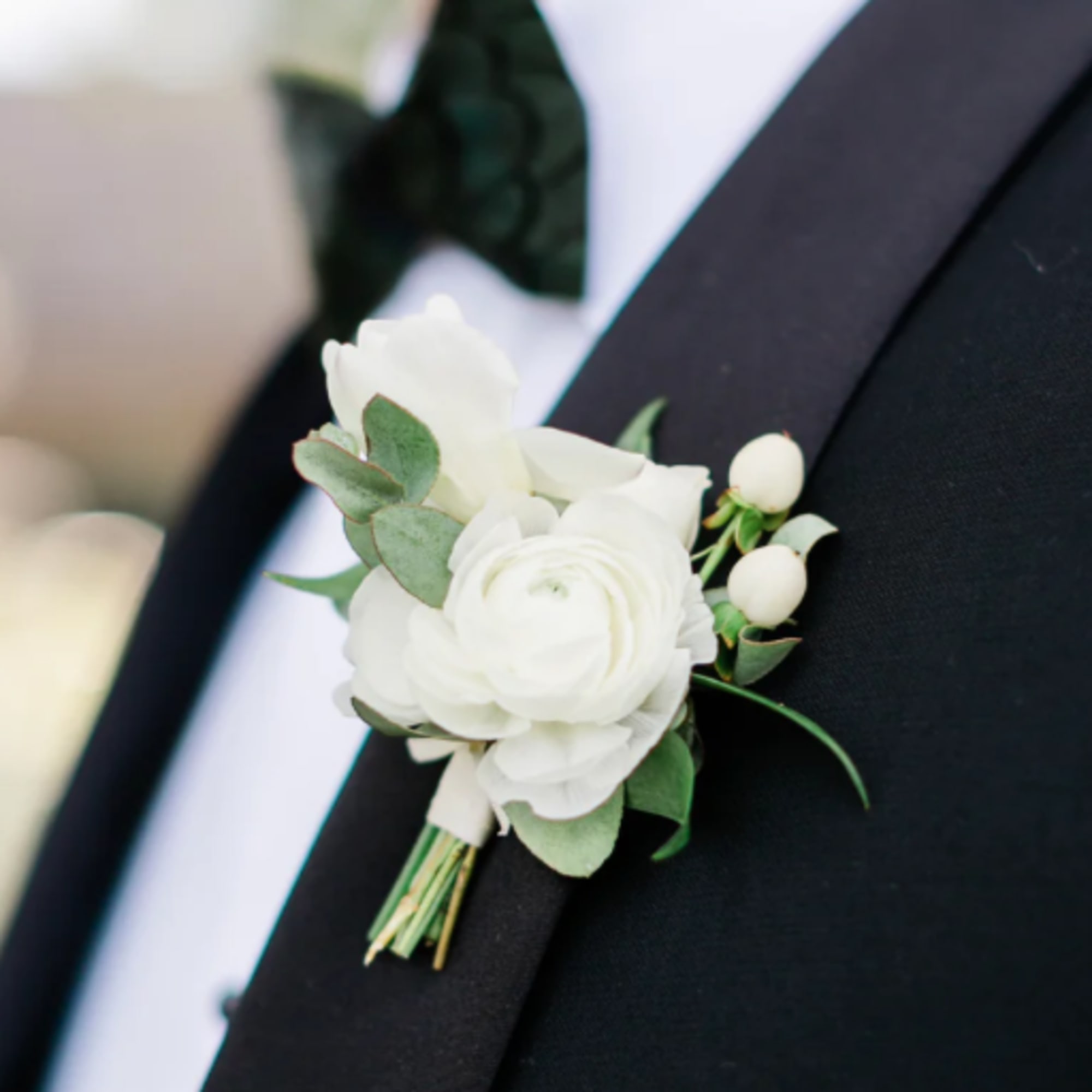White boutonniere pinned to a black suit jacket