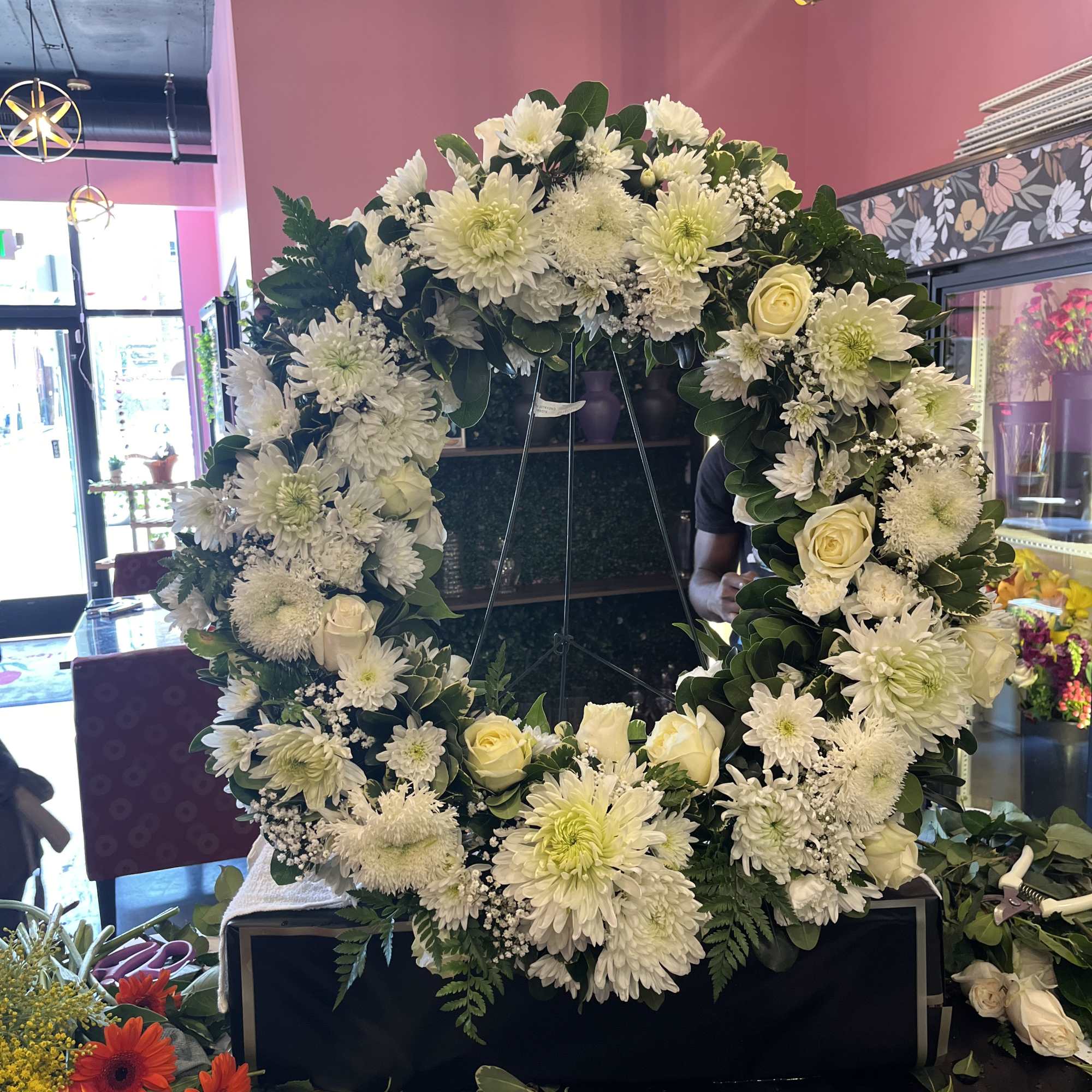 Large white floral wreath on a stand with roses and chrysanthemums, photo 4 of 4