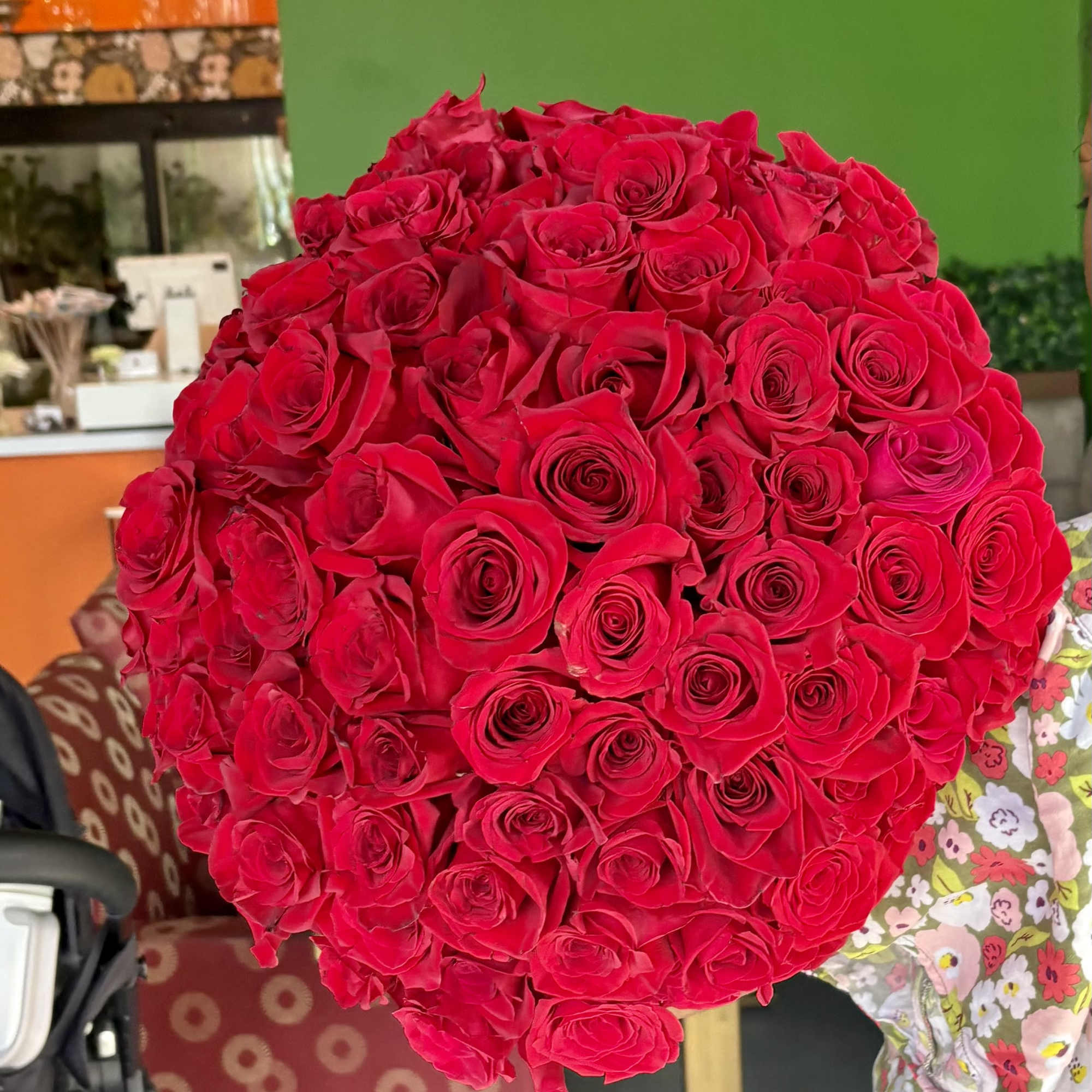 Large bouquet of red roses held indoors