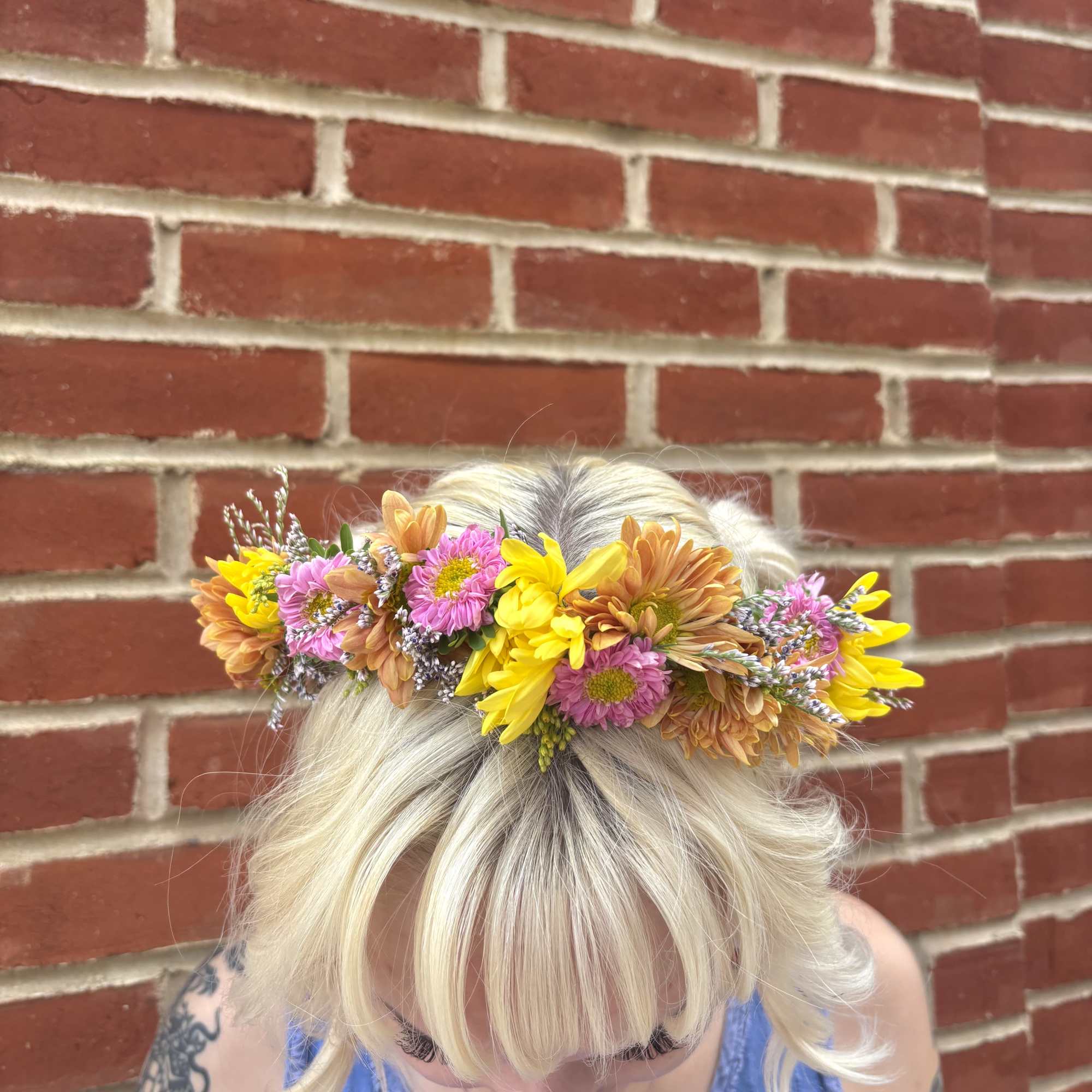 Flower crown with pink, yellow, and peach blooms worn on a person's head