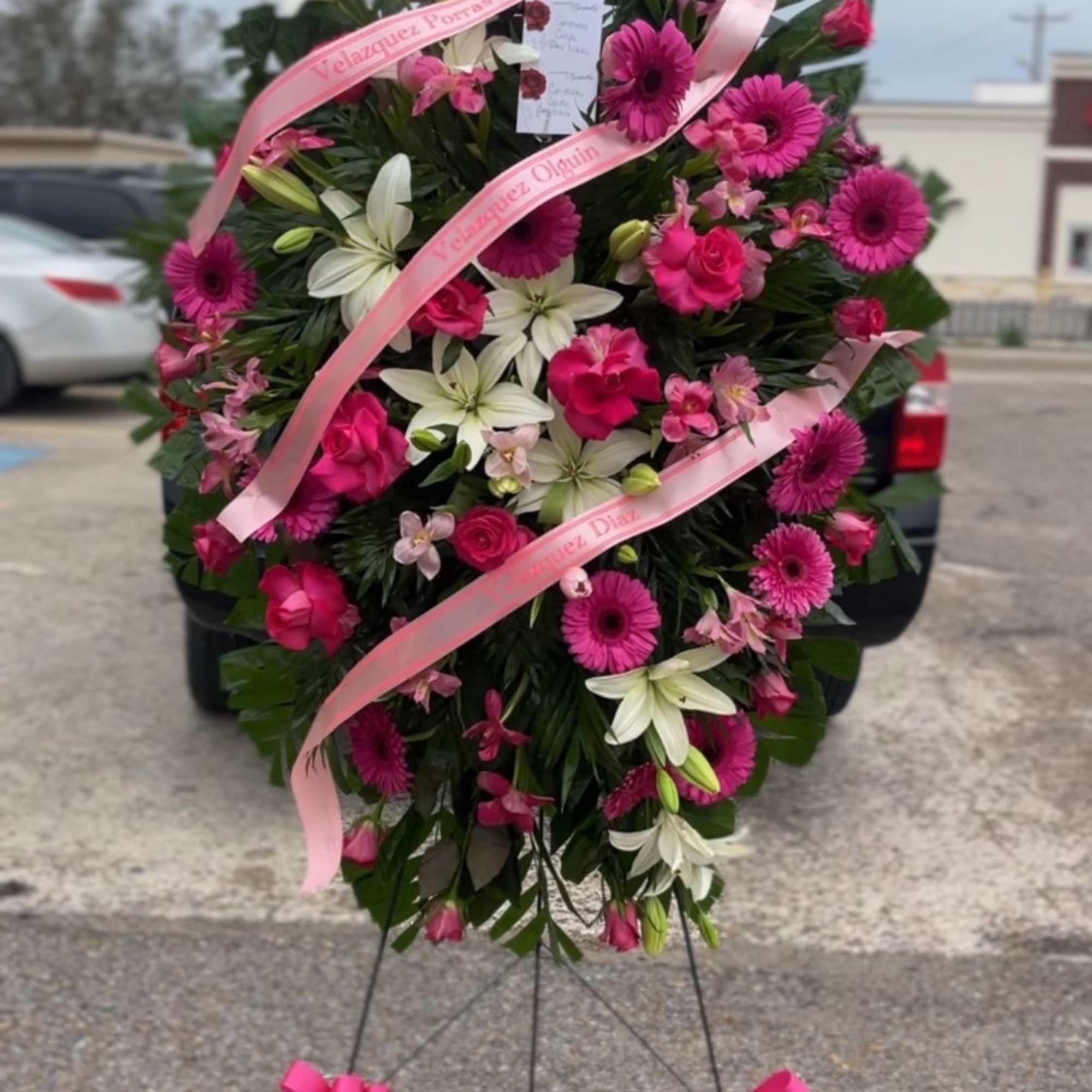 Bright, ceremonial pink and white standing spray designed for sympathy and memorials