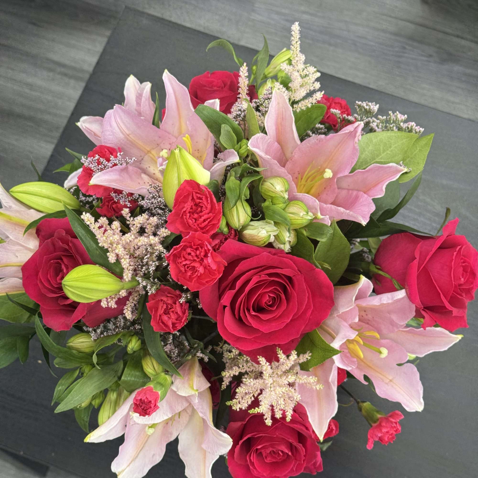 Bouquet of pink lilies and red roses with small filler flowers