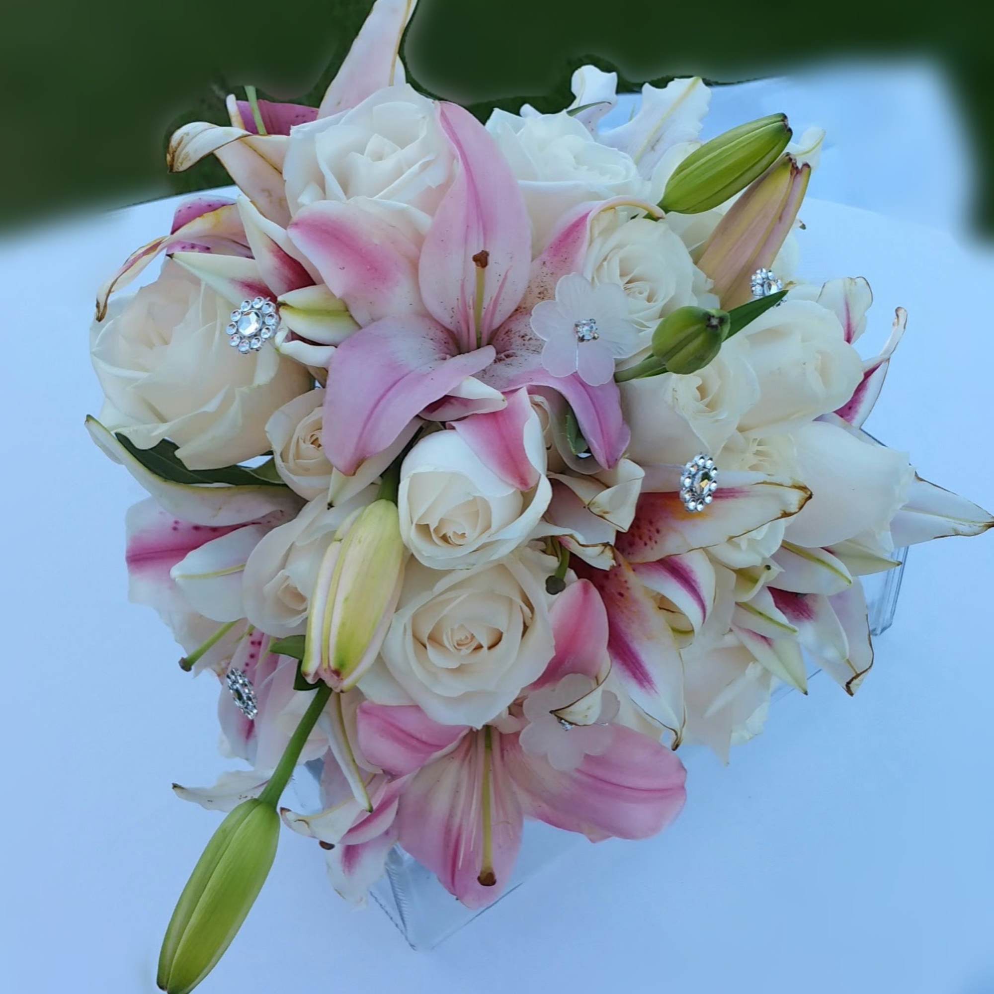 Pink and white bouquet of roses and lilies with jeweled accents