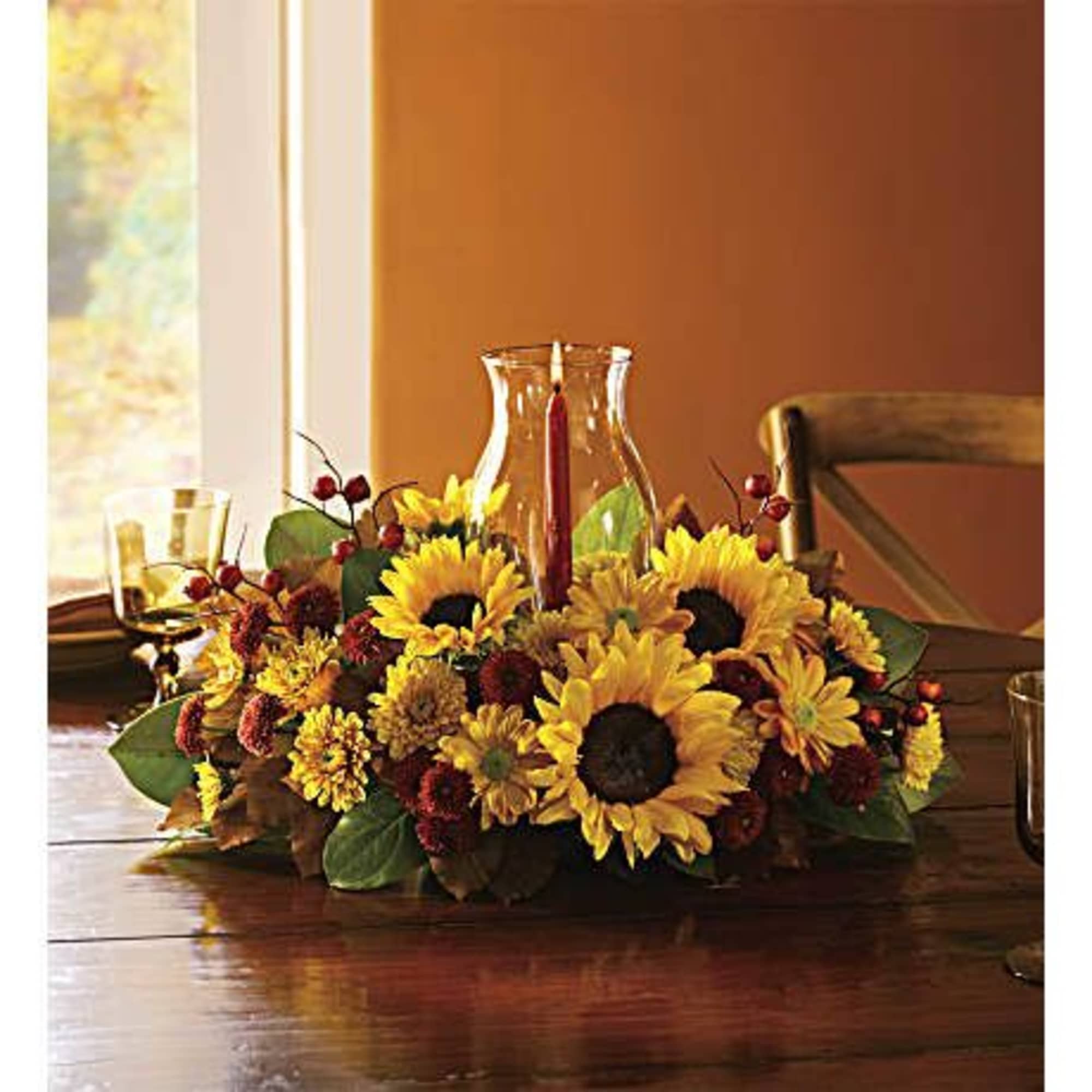 Low centerpiece with sunflowers and autumn flowers on a dining table