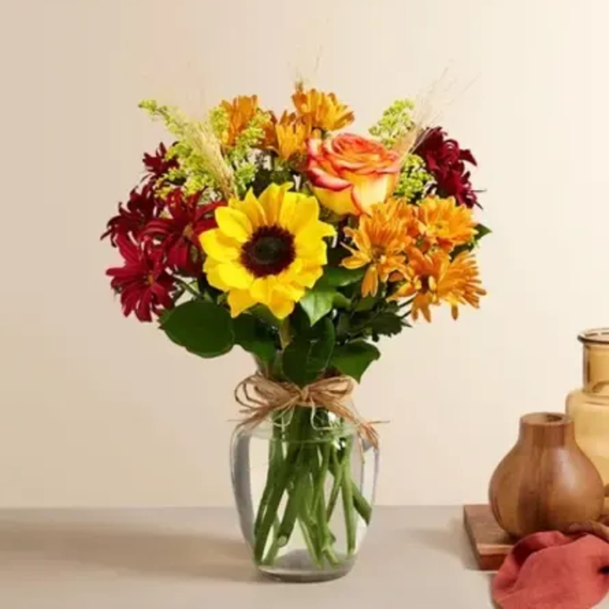 Mixed bouquet of sunflowers, roses, and chrysanthemums in a glass vase