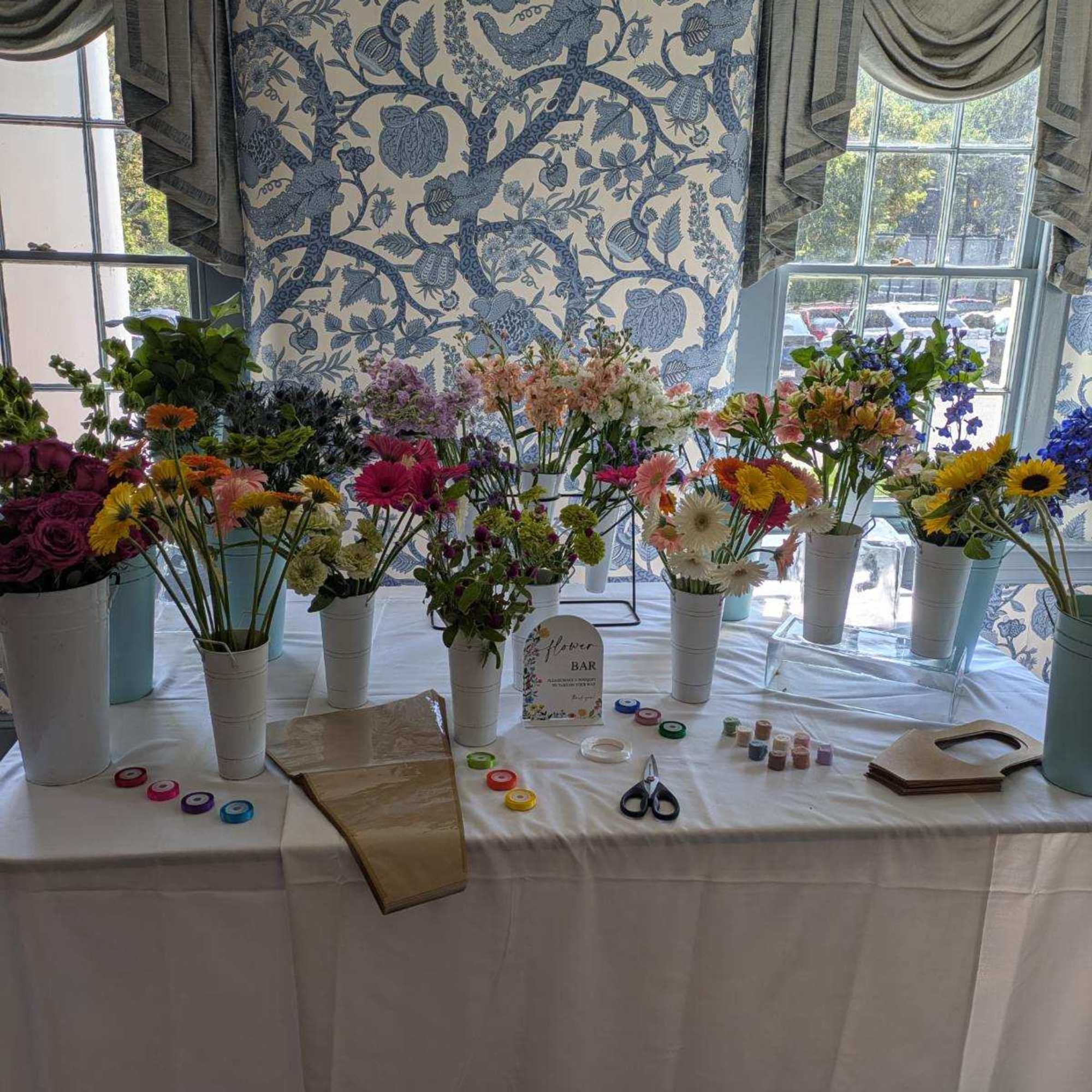 Flower bar table with assorted bouquets in white cups
