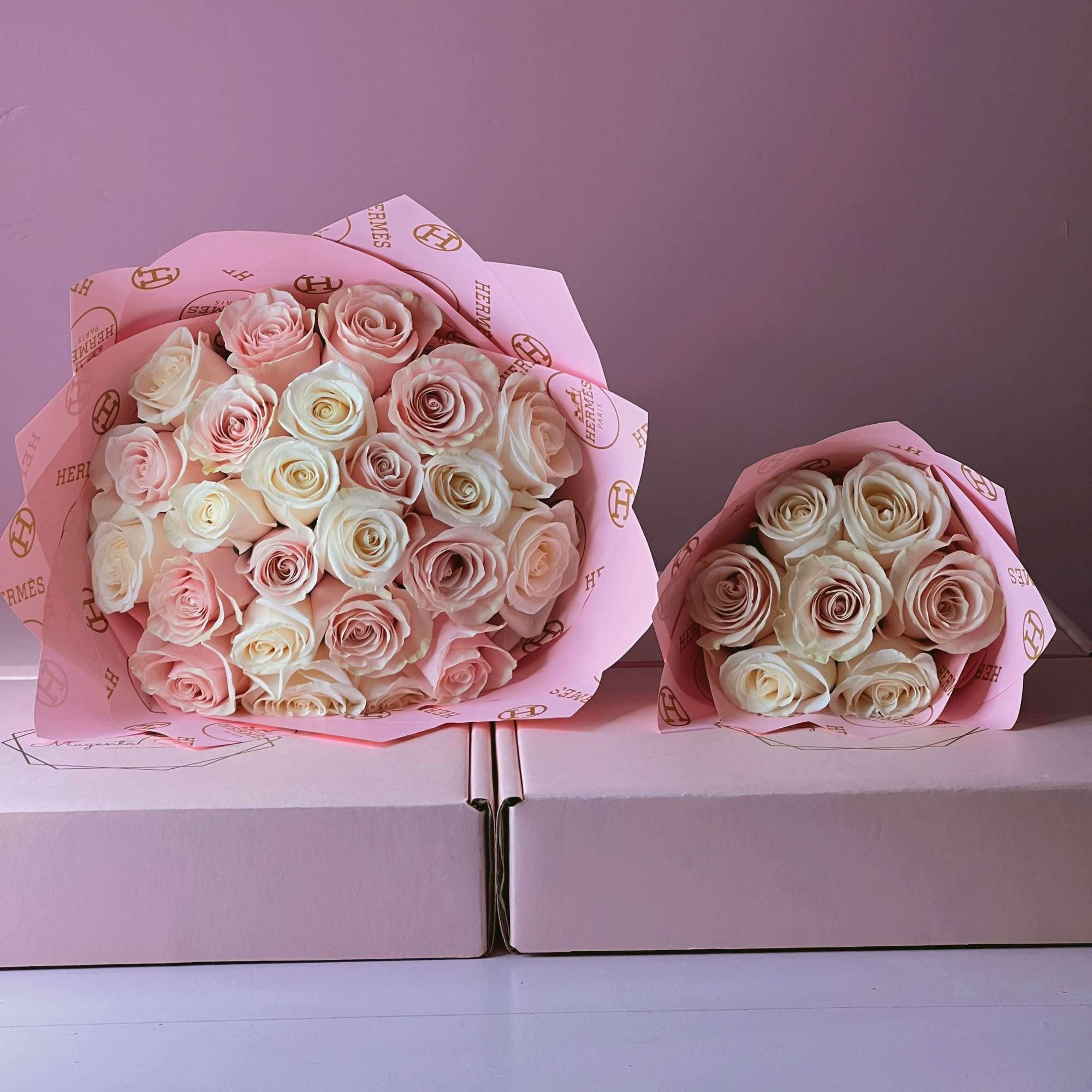 Two bouquets of pale pink and cream roses wrapped in pink paper