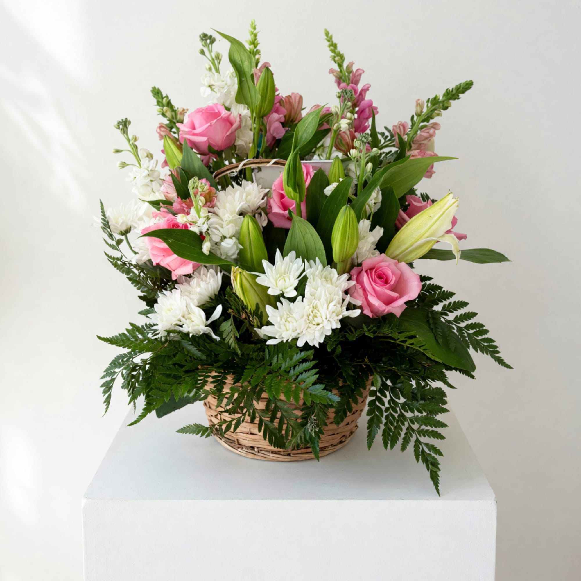 Pink roses and white lilies in a wicker basket