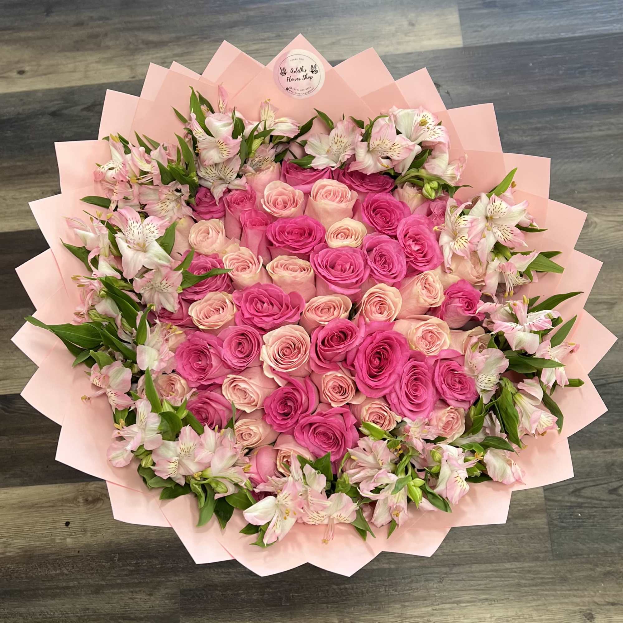 Large bouquet of pink roses and pale pink alstroemeria wrapped in blush paper