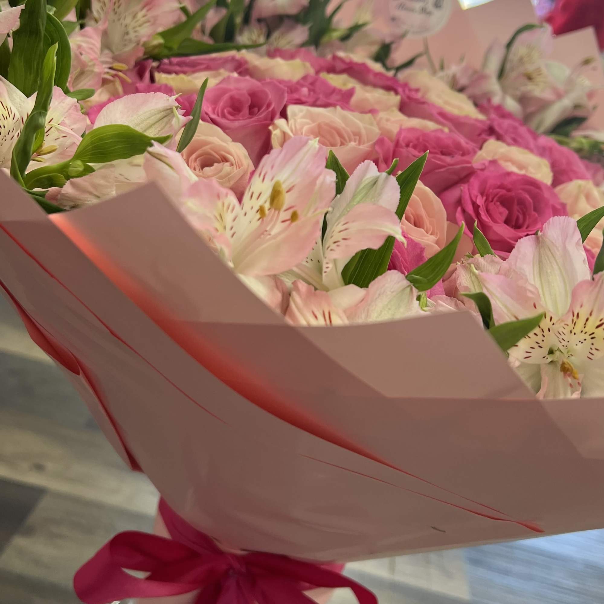 Pink rose bouquet with white alstroemeria in pink wrap and ribbon
