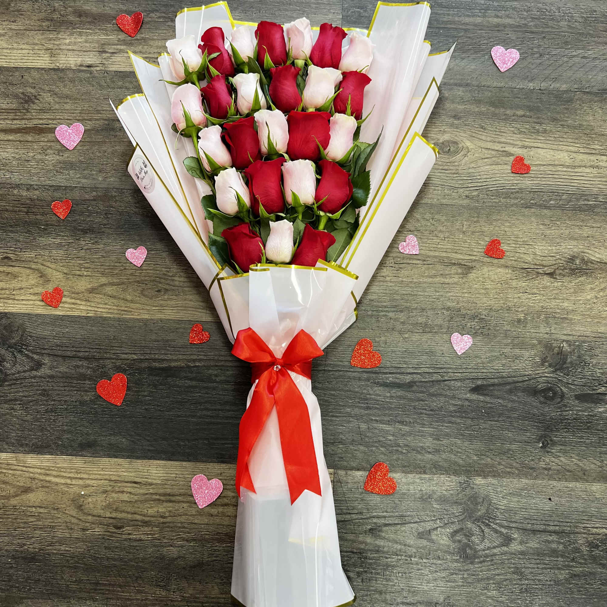 Bouquet of red and pale pink roses wrapped in white paper with a red ribbon, photo 3 of 3