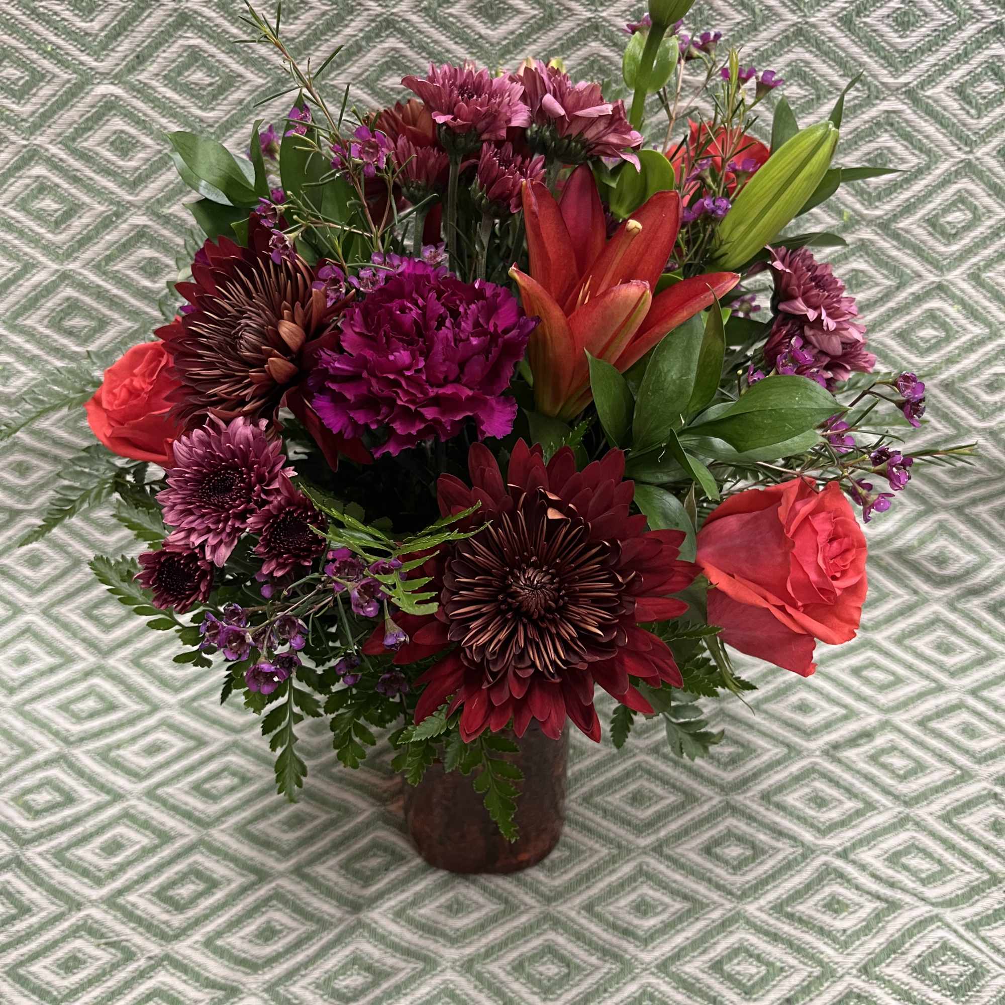 Bouquet of red and purple flowers in a dark vase