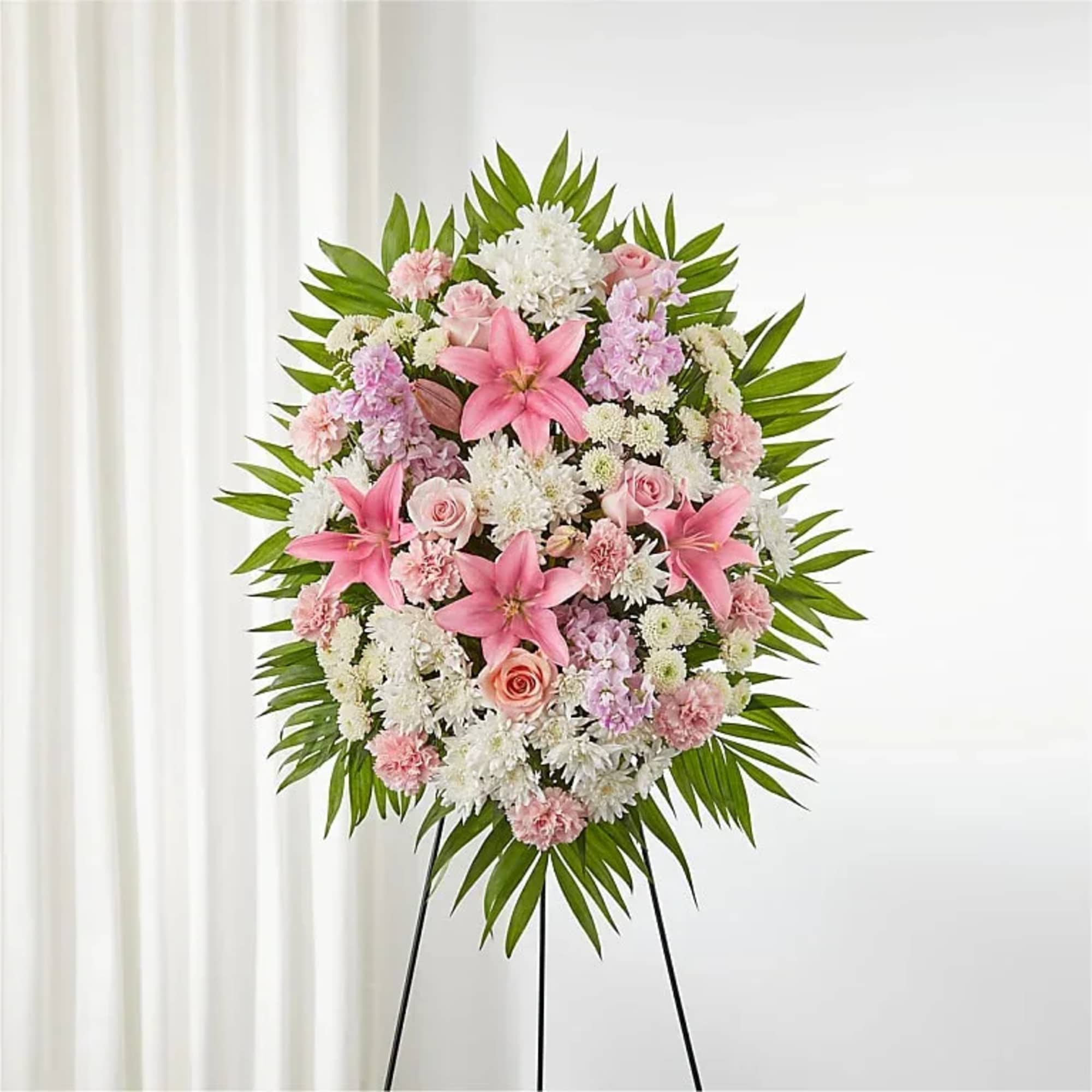 Standing floral wreath with pink and white flowers on a black easel