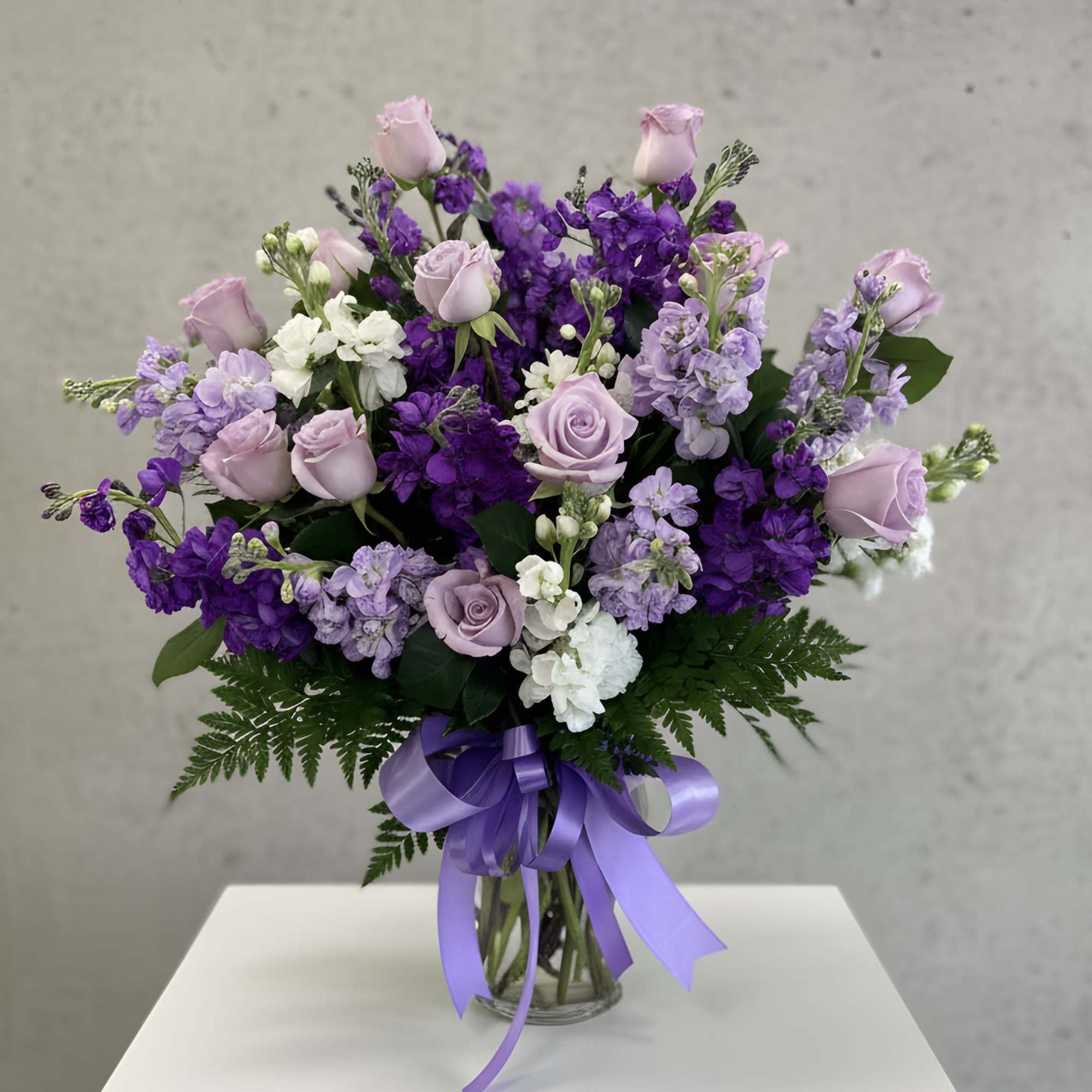 A soft and elegant arrangement featuring delicate lavender looms. Designed in a