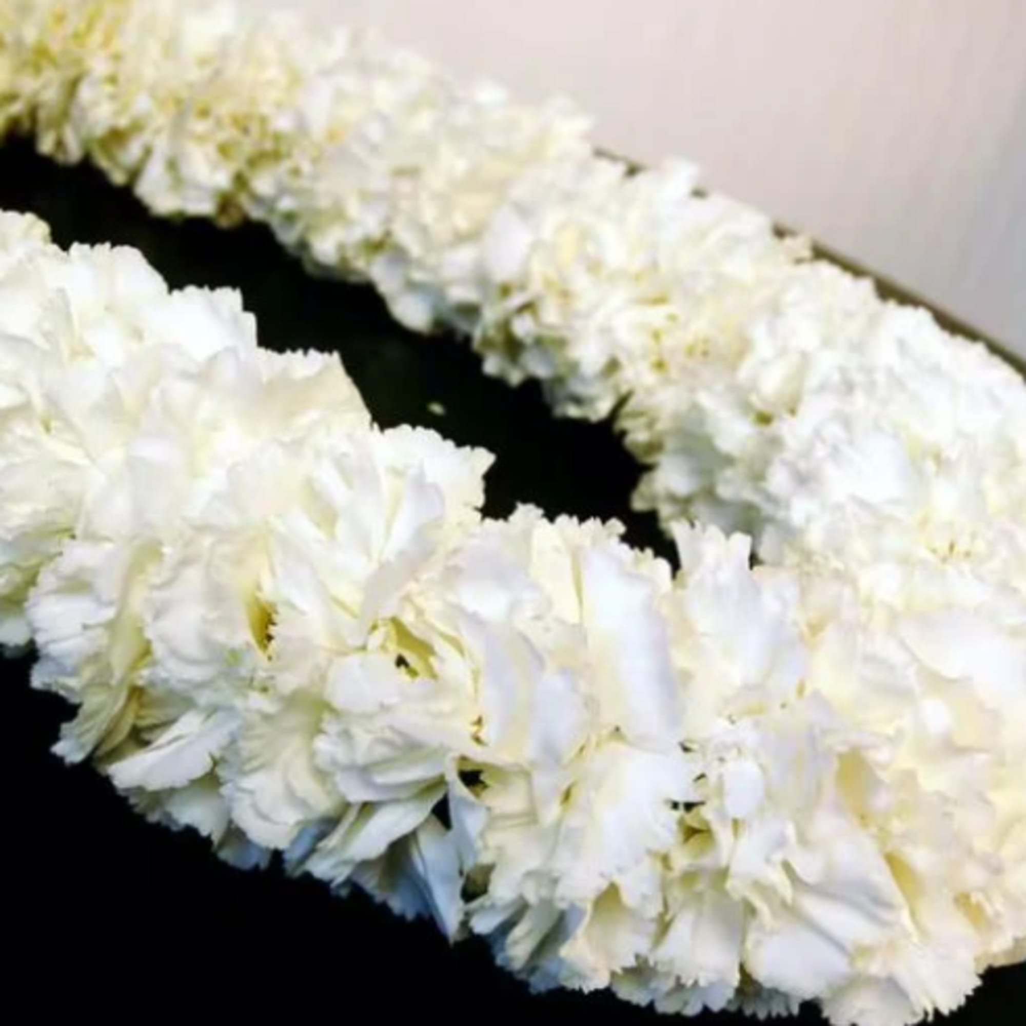 White floral lei on a dark surface
