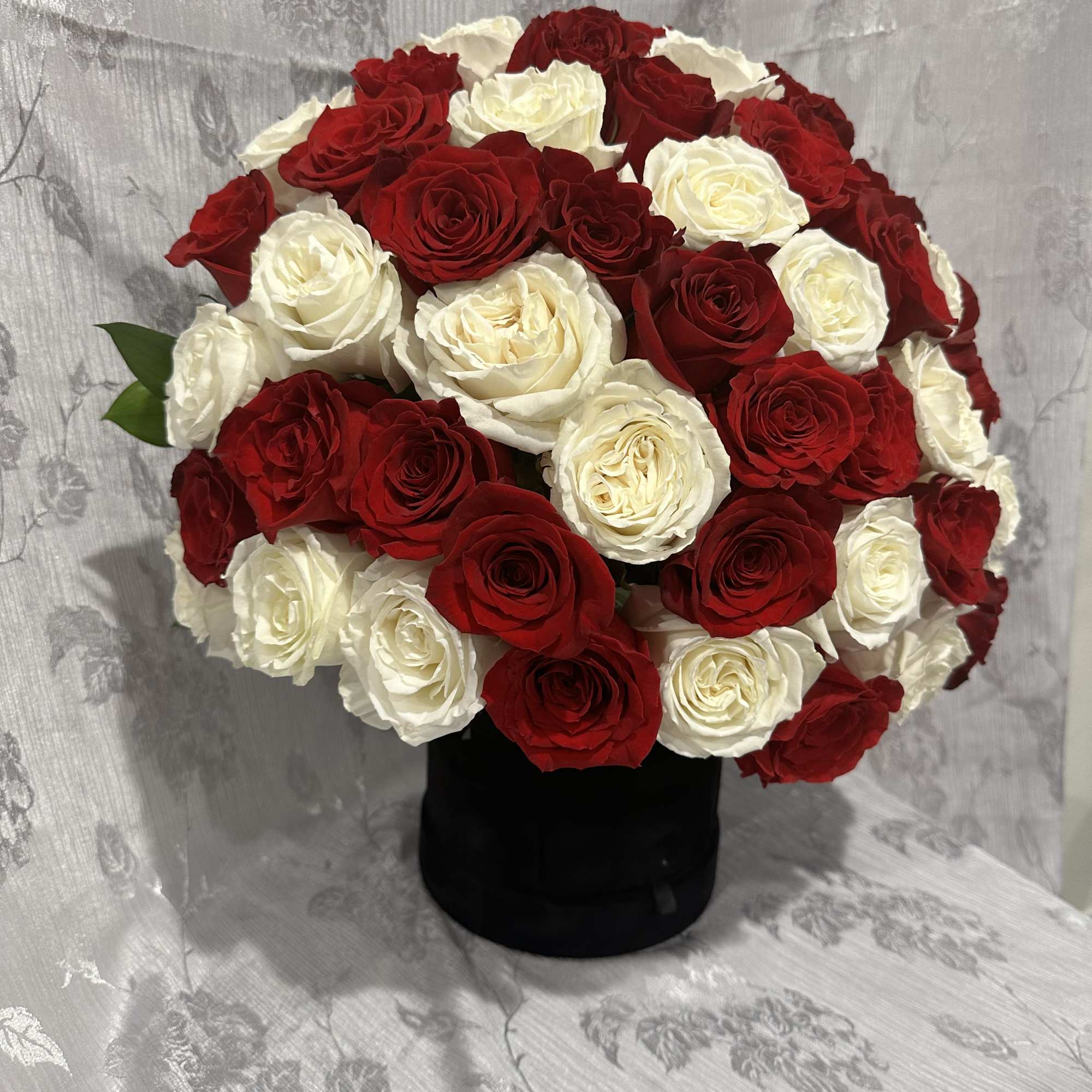 Red and white rose bouquet in a black vase, photo 2 of 5