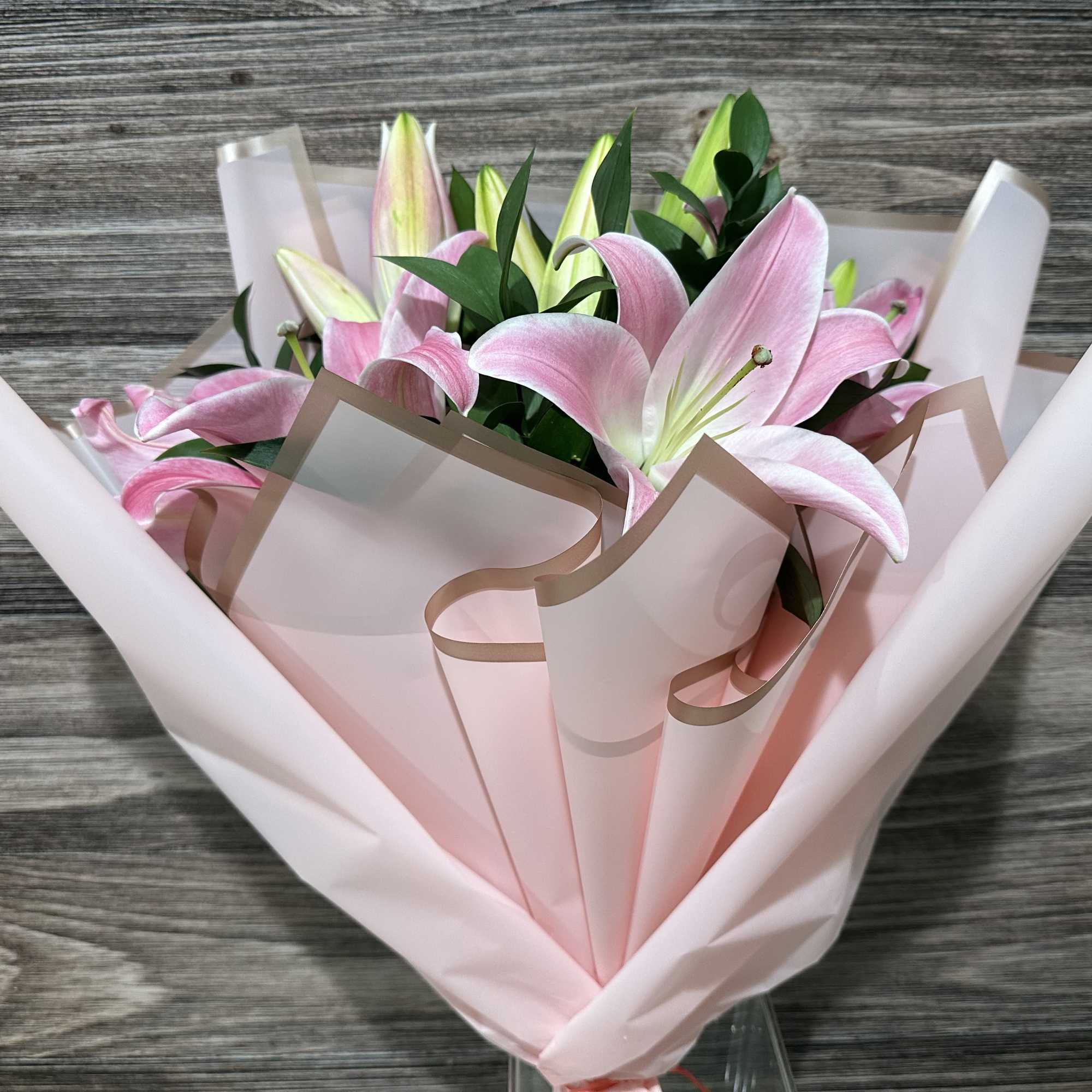 Pink lilies wrapped in pale pink paper