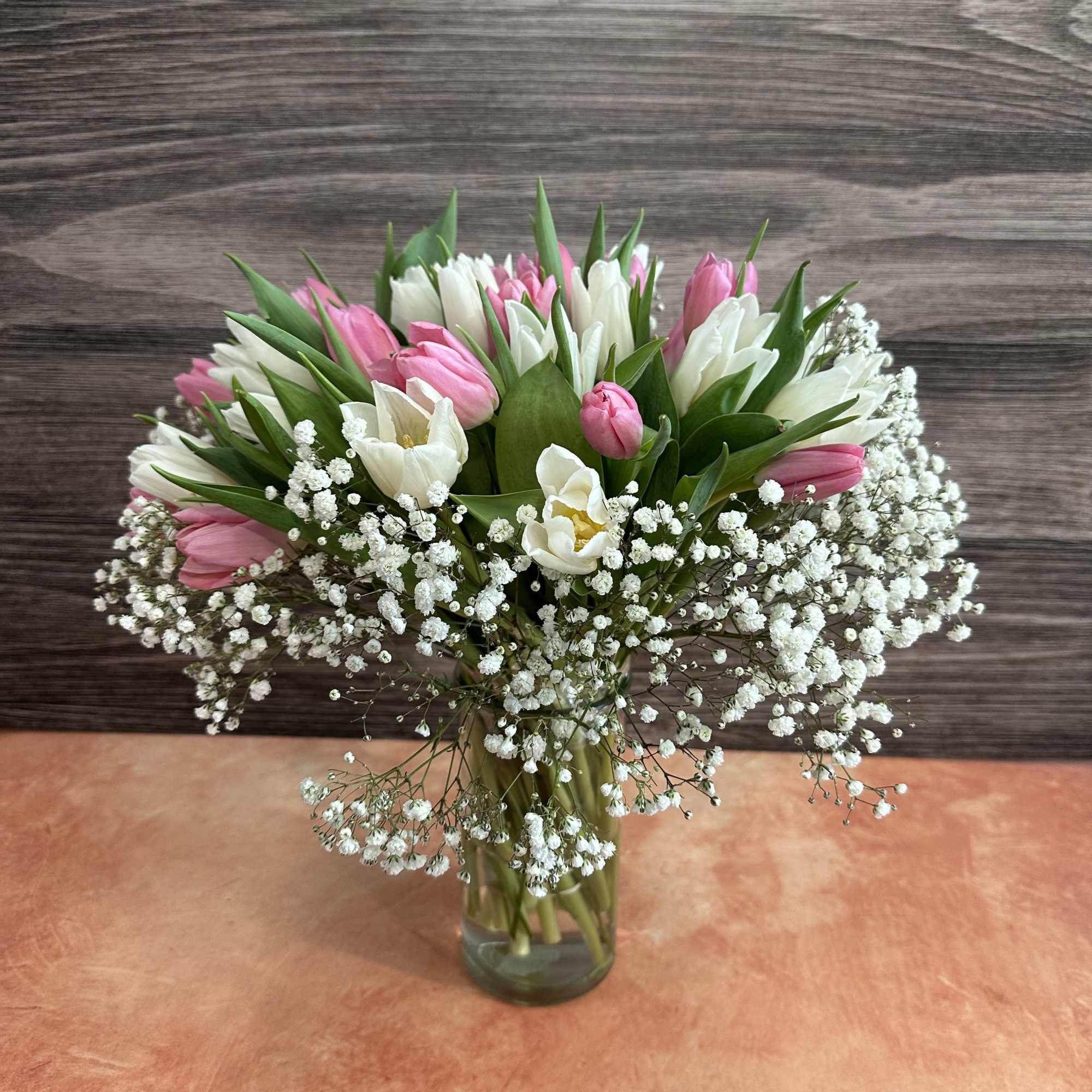 Pink and white tulip bouquet in a glass vase