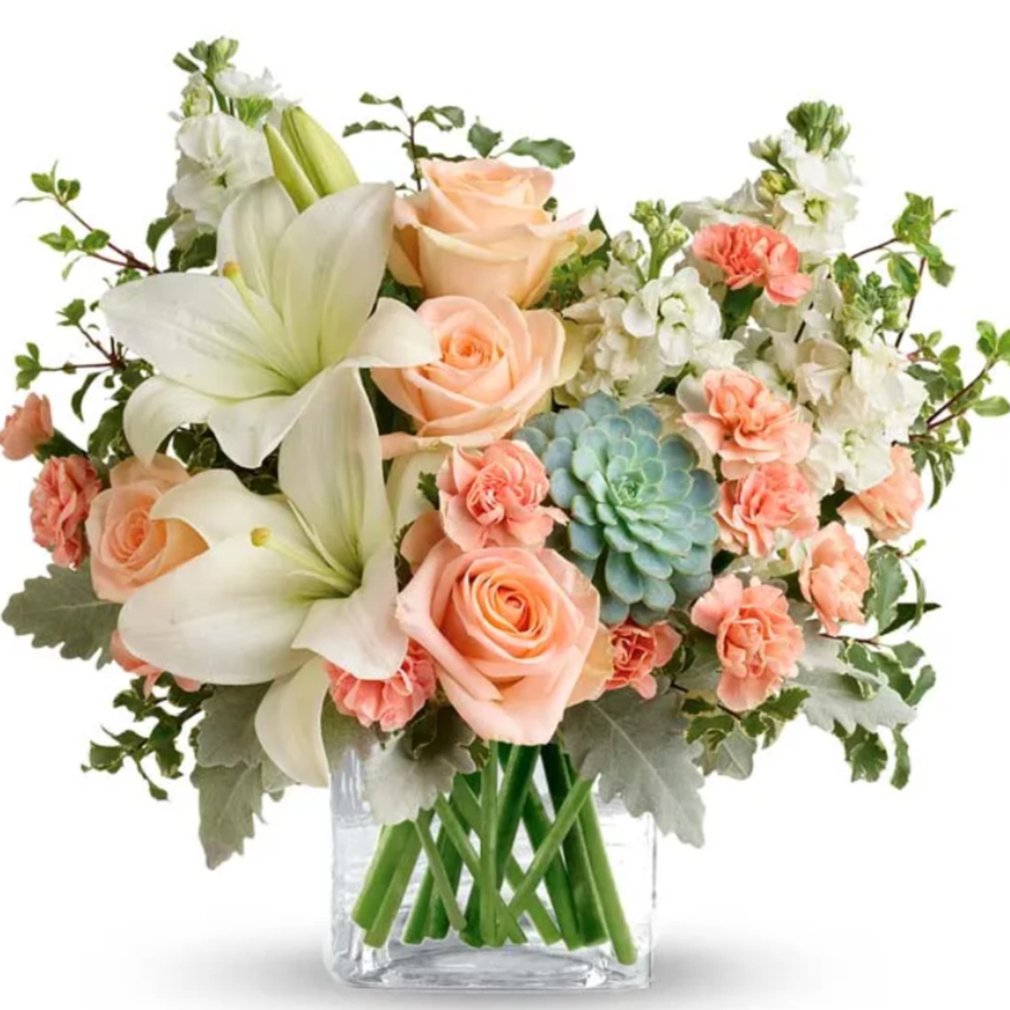 Peach roses and white lilies in a clear glass vase