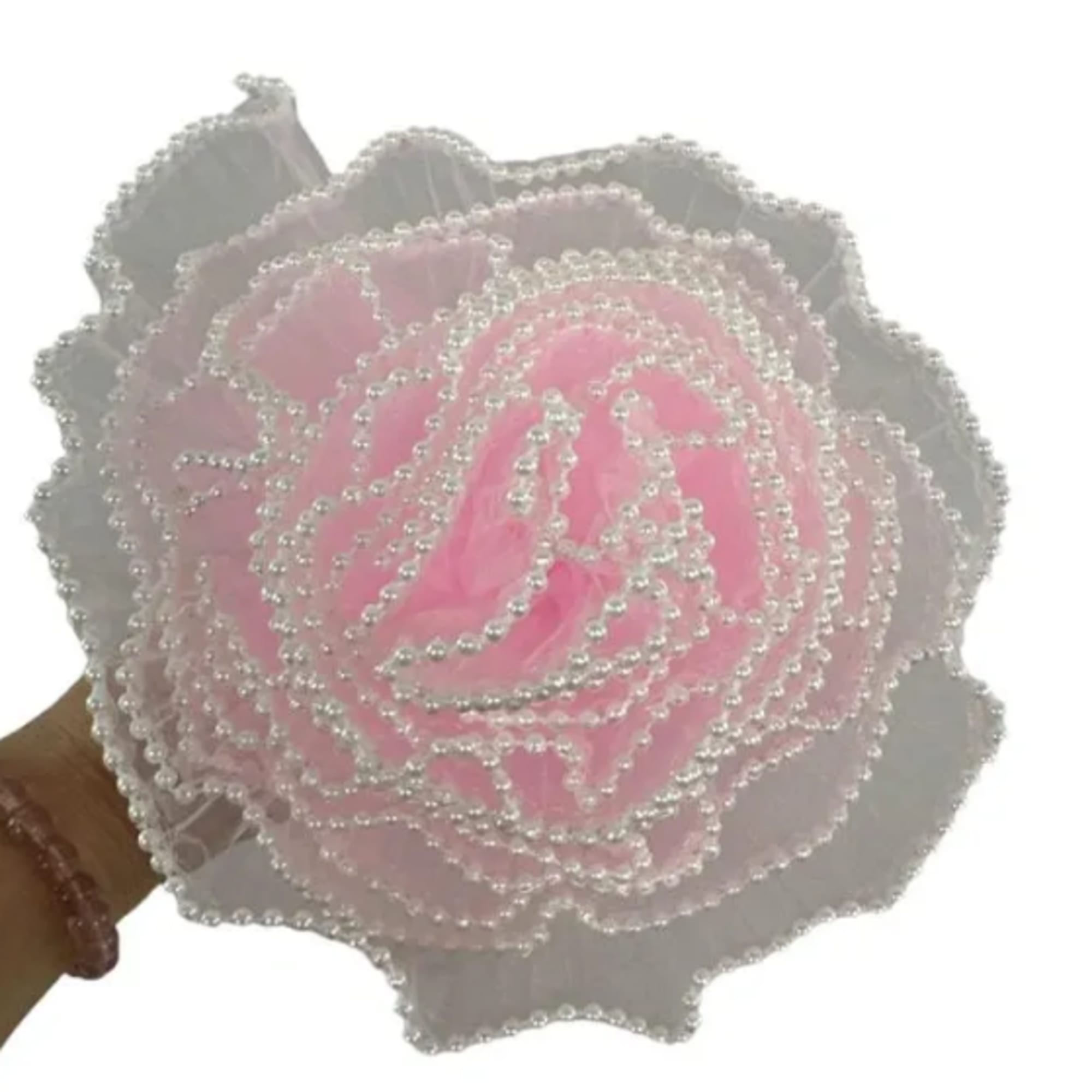 Pink beaded artificial rose held in a hand