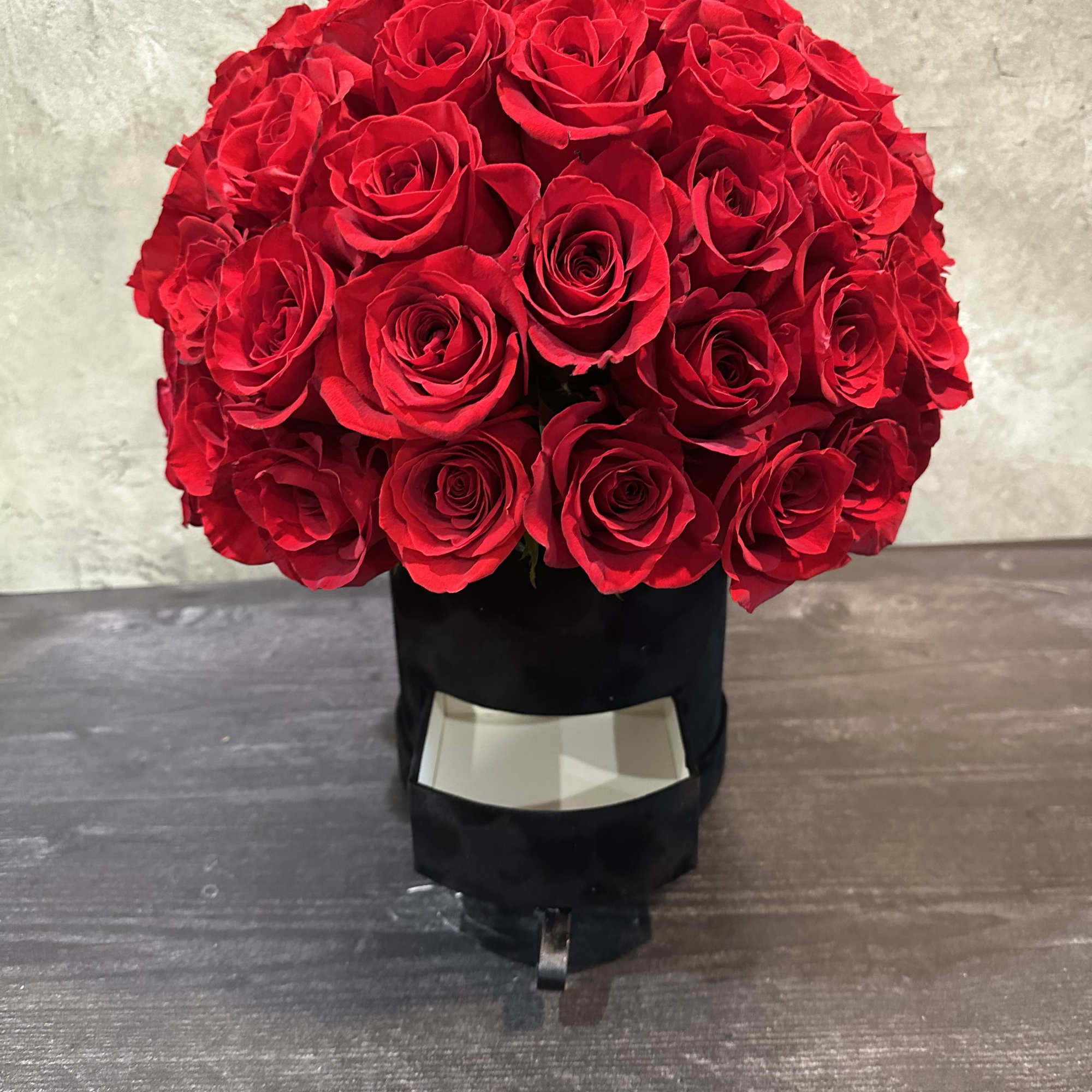 Large bouquet of red roses in a black box