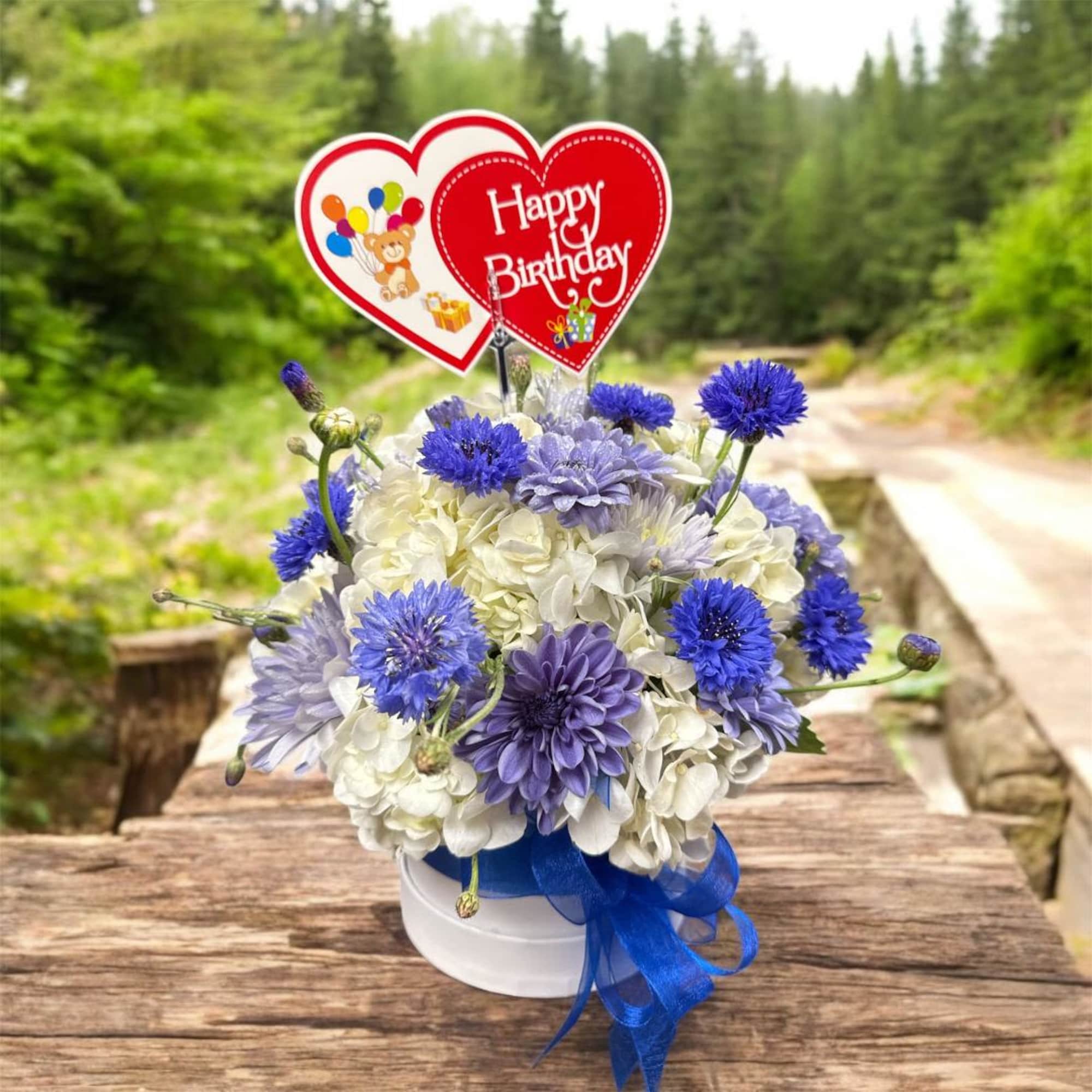 Blue and white flower arrangement in a white box with a Happy Birthday topper