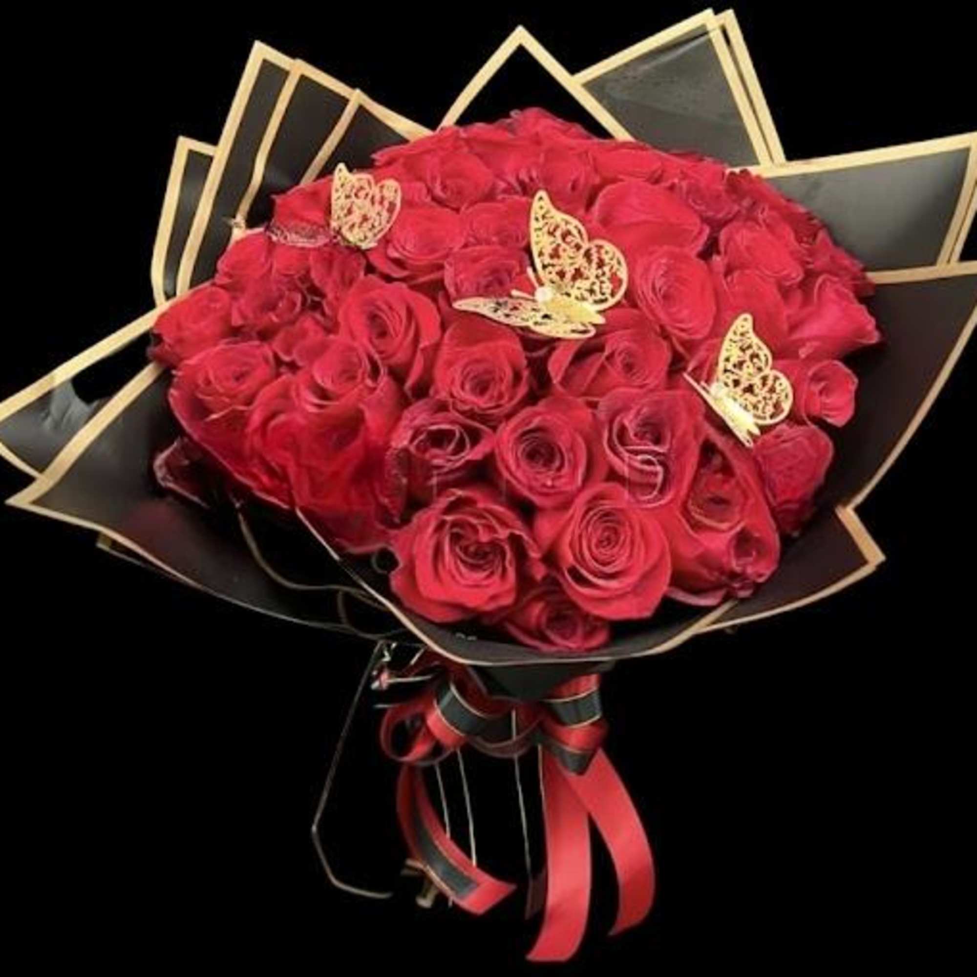Bouquet of red roses wrapped in black paper with gold trim