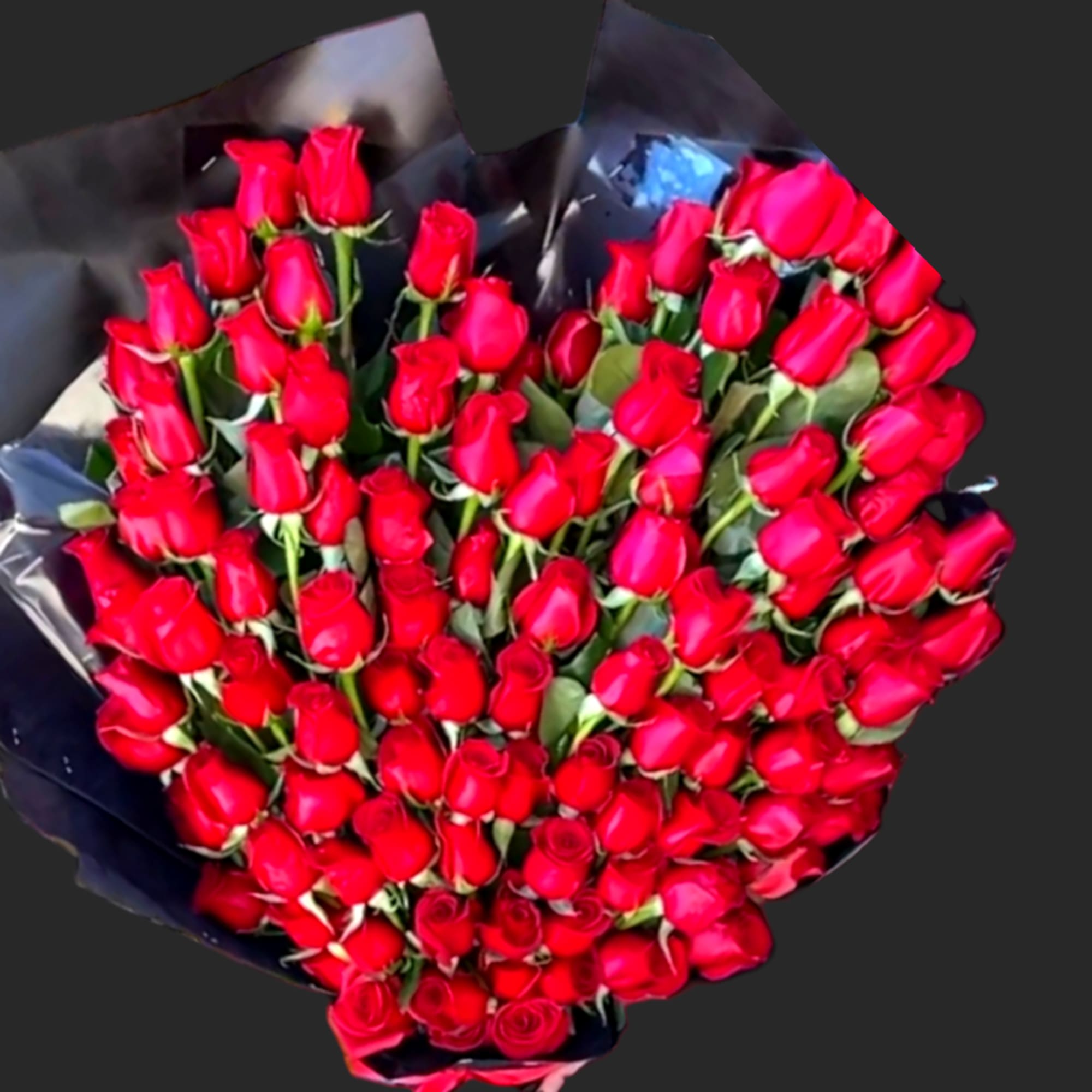 Large bouquet of red roses wrapped in dark paper