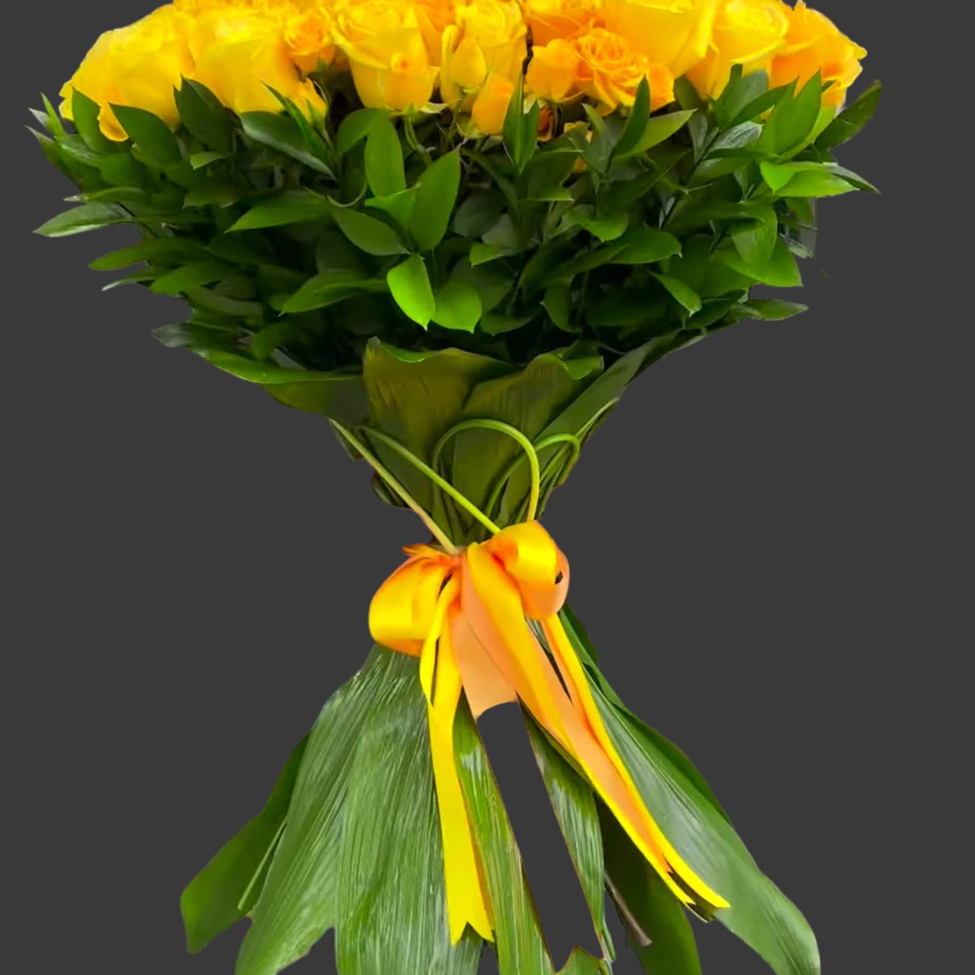 Bouquet of yellow roses wrapped with green leaves and a yellow ribbon