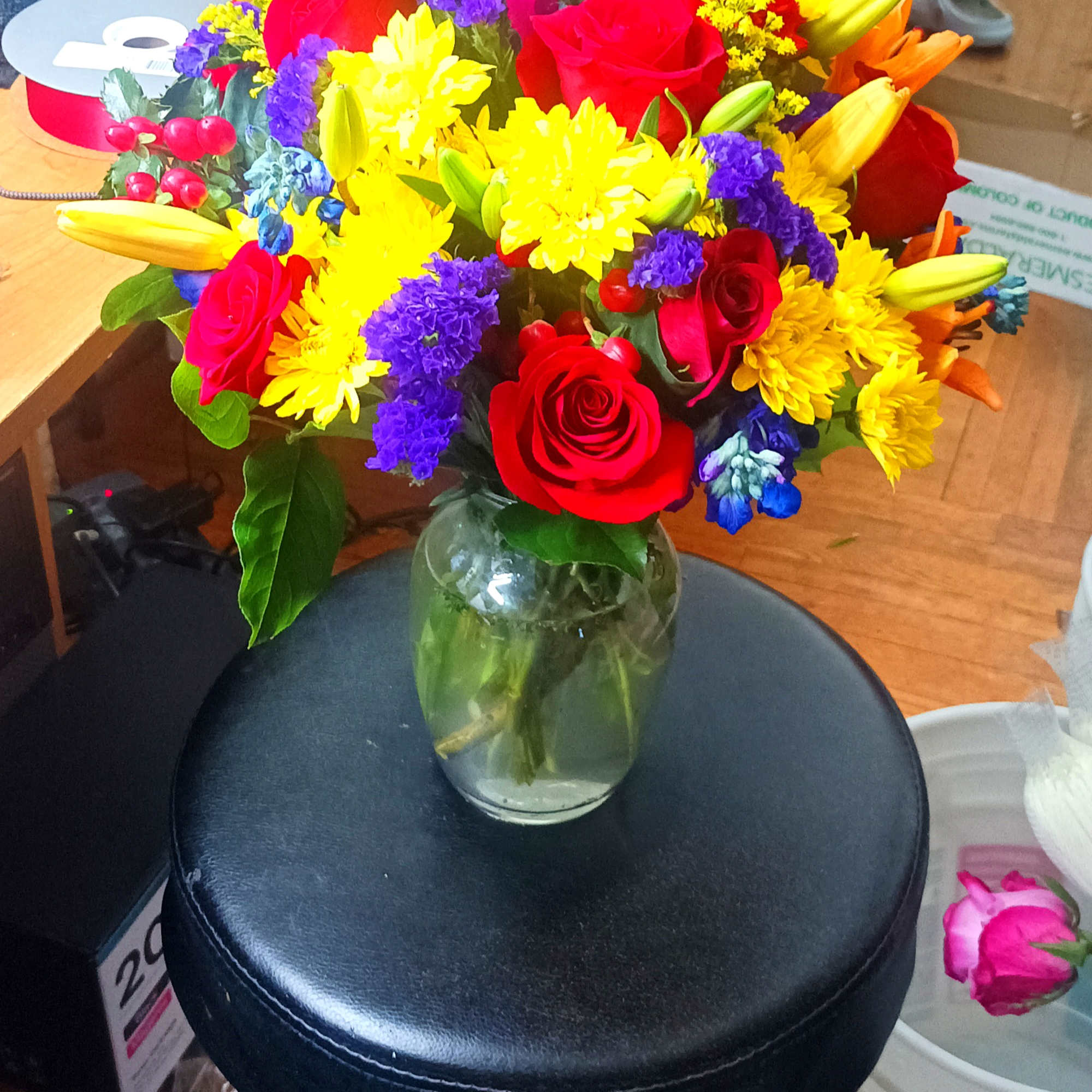 Colorful bouquet of roses, lilies, and chrysanthemums in a glass vase