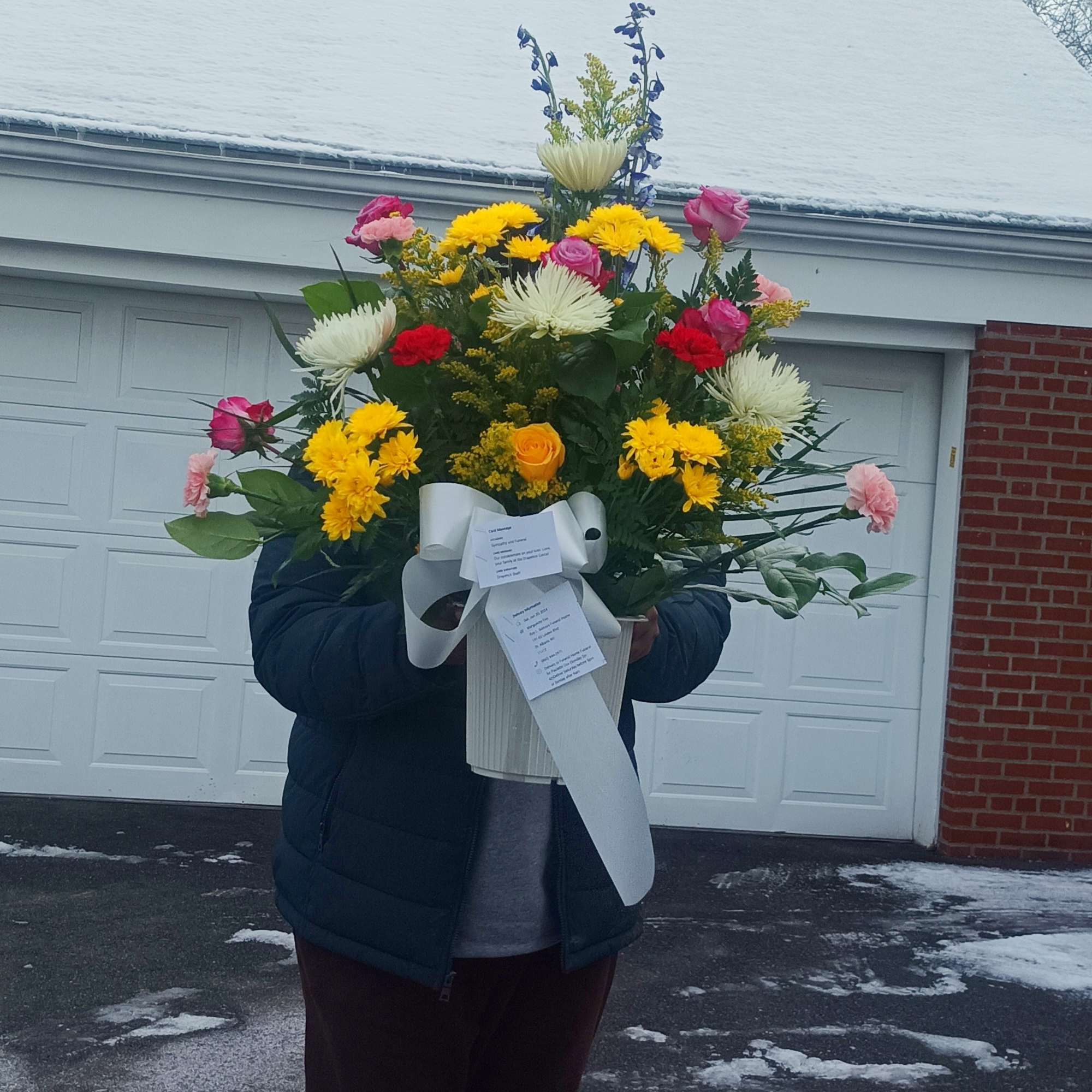 Large mixed bouquet in a white container with a ribbon