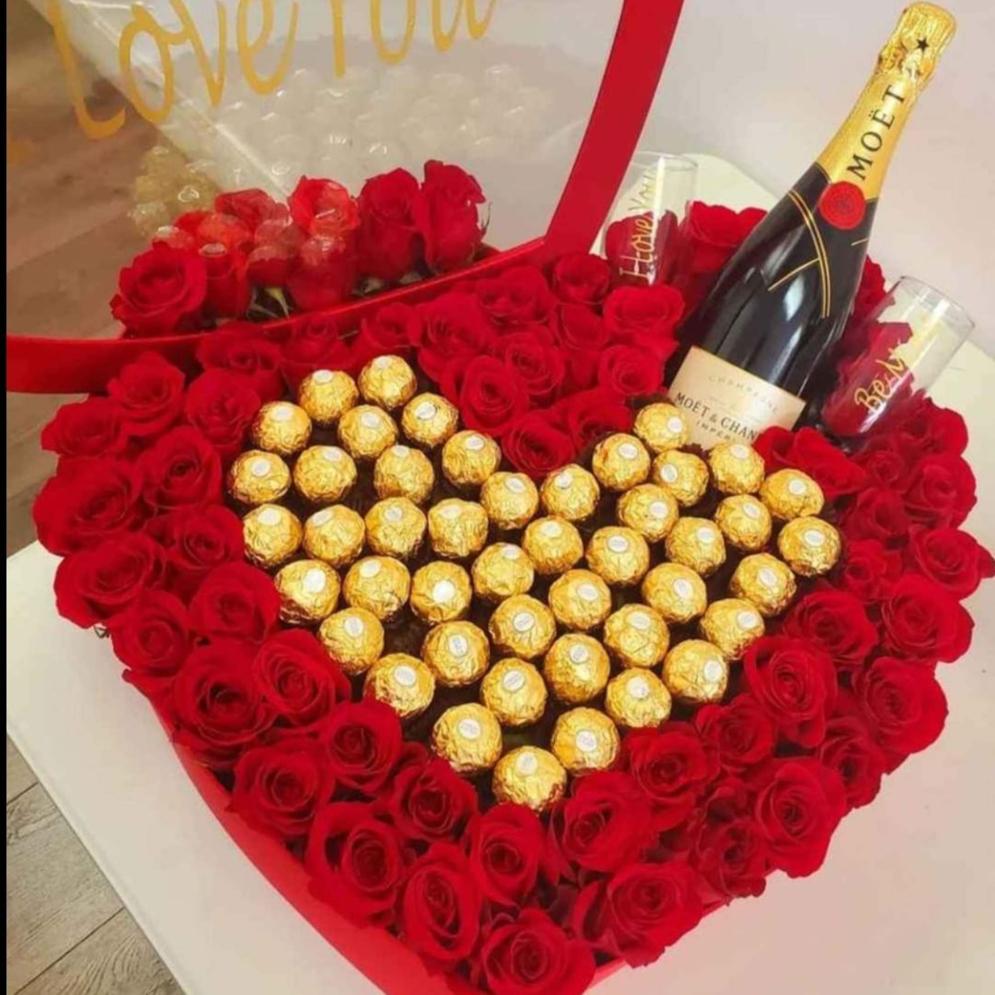 Heart-shaped box of red roses with gold-wrapped chocolates and a champagne bottle, photo 2 of 7