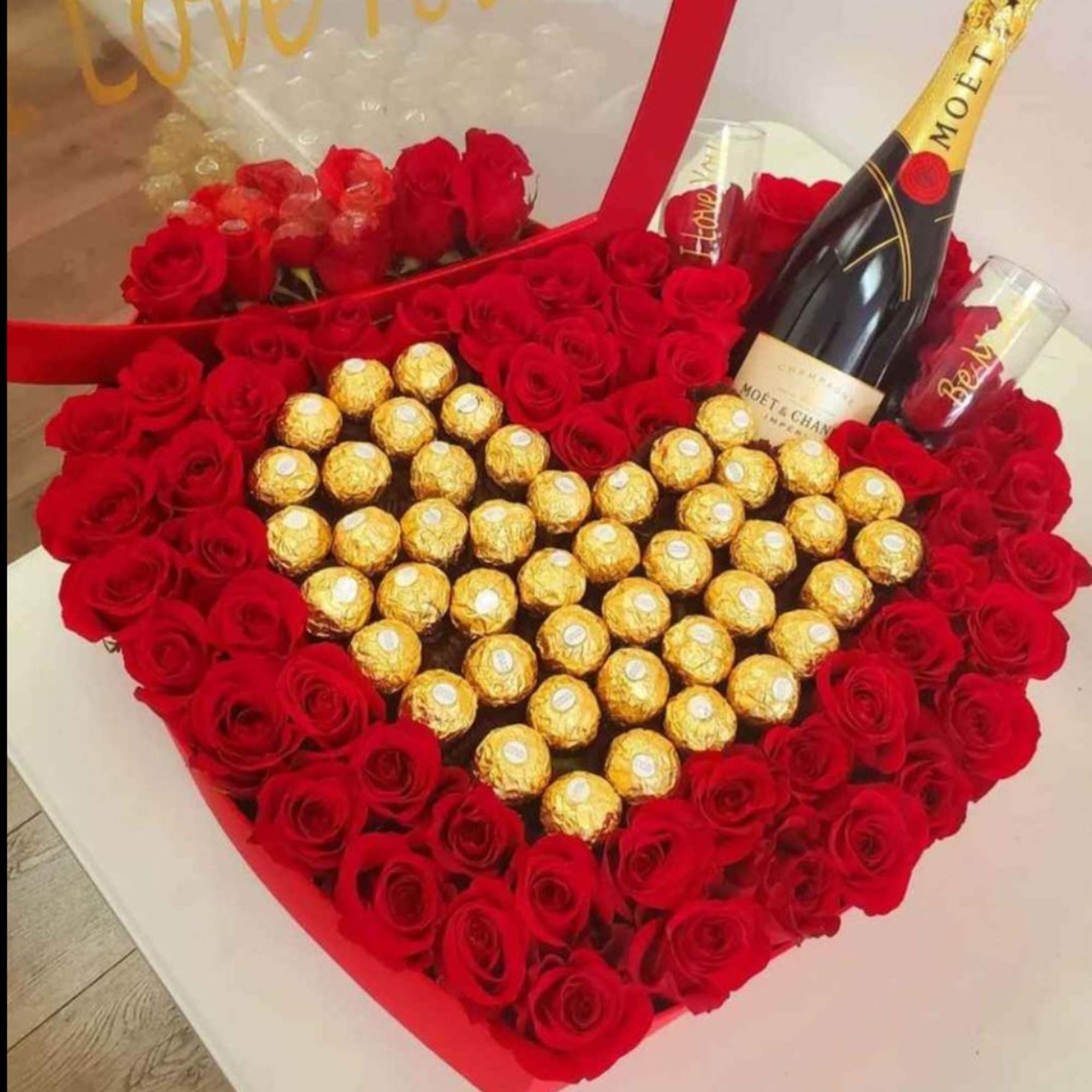 Heart-shaped box of red roses with gold-wrapped chocolates and a champagne bottle, photo 3 of 7