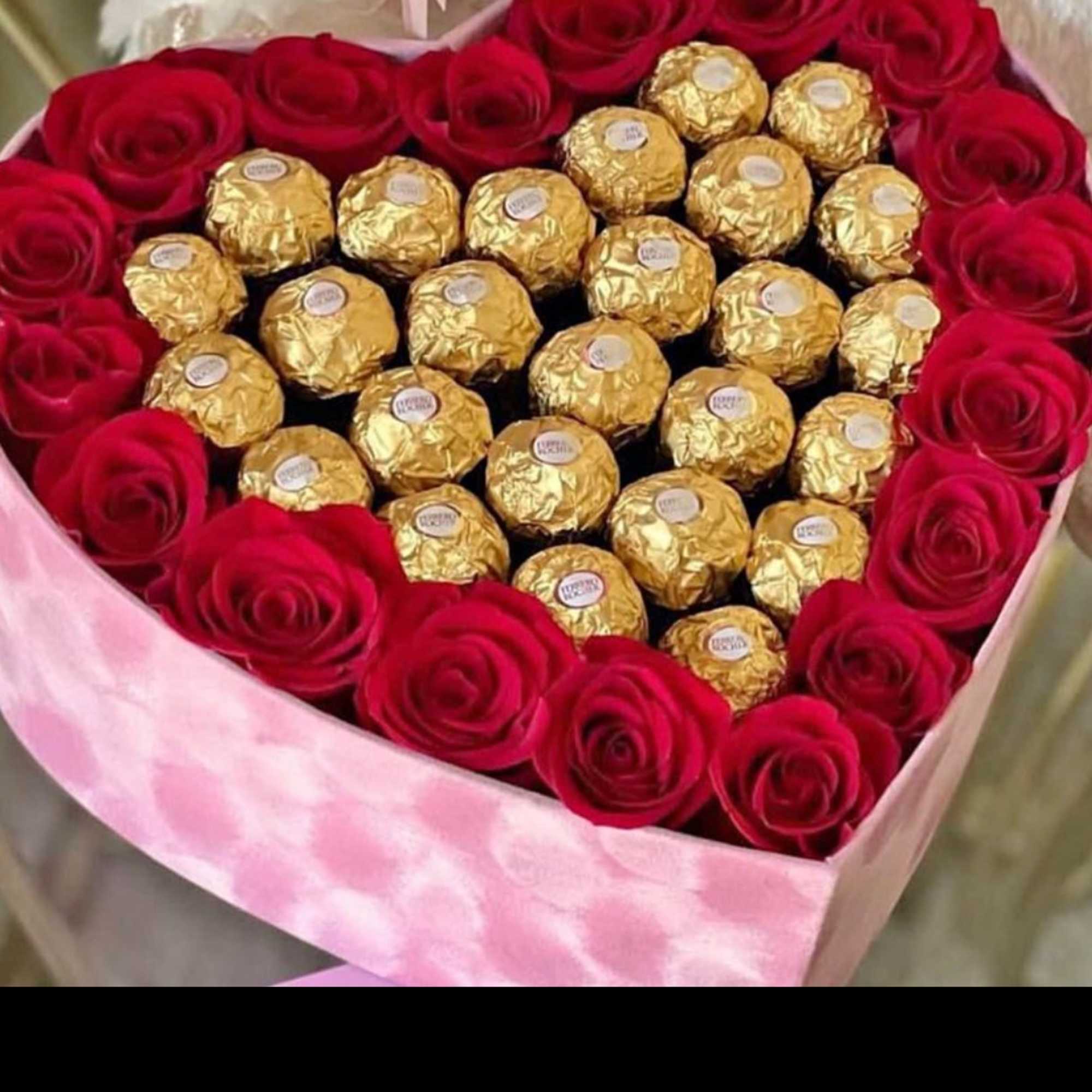 Heart-shaped box of red roses and gold-wrapped chocolates