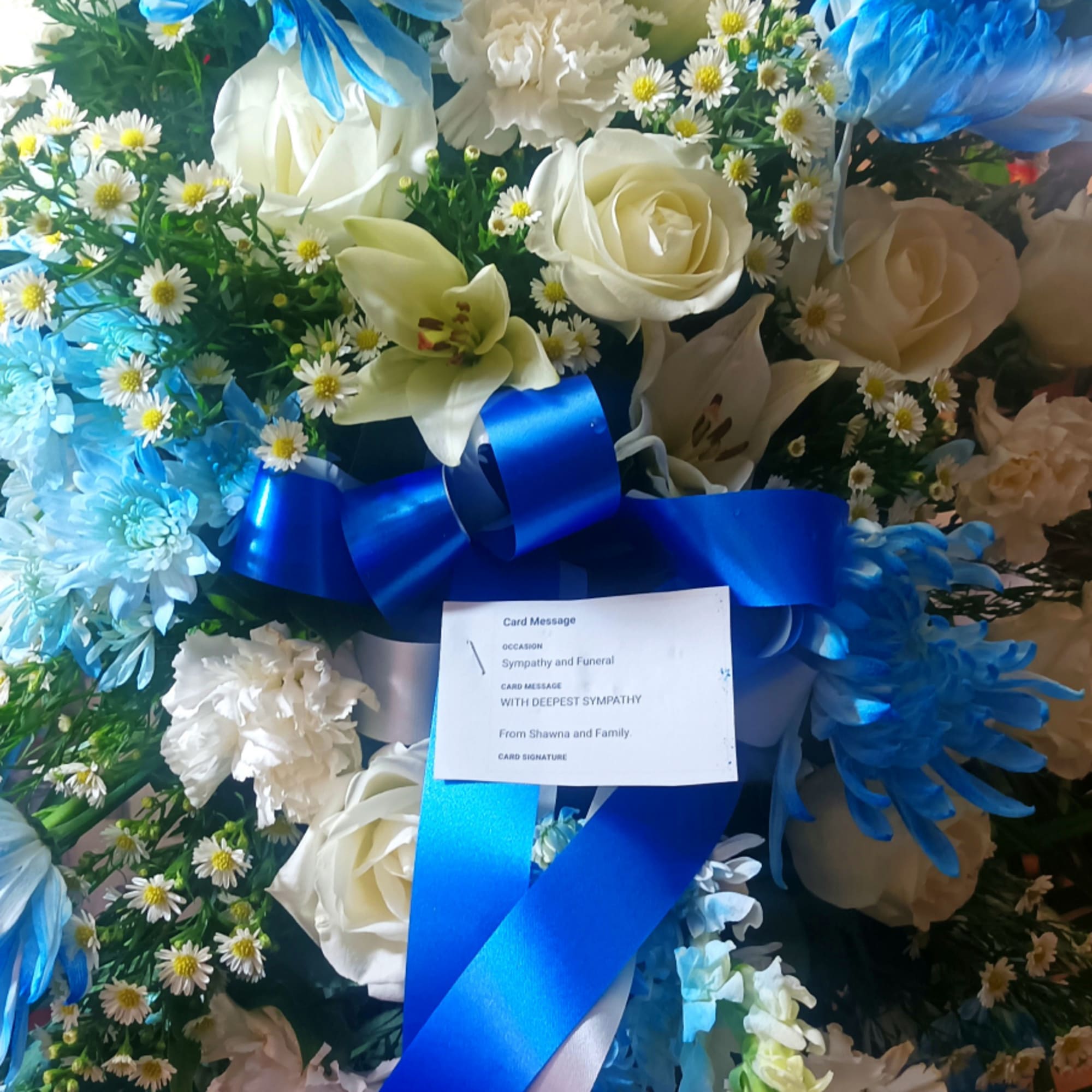 Blue and white sympathy floral spray with ribbon and card