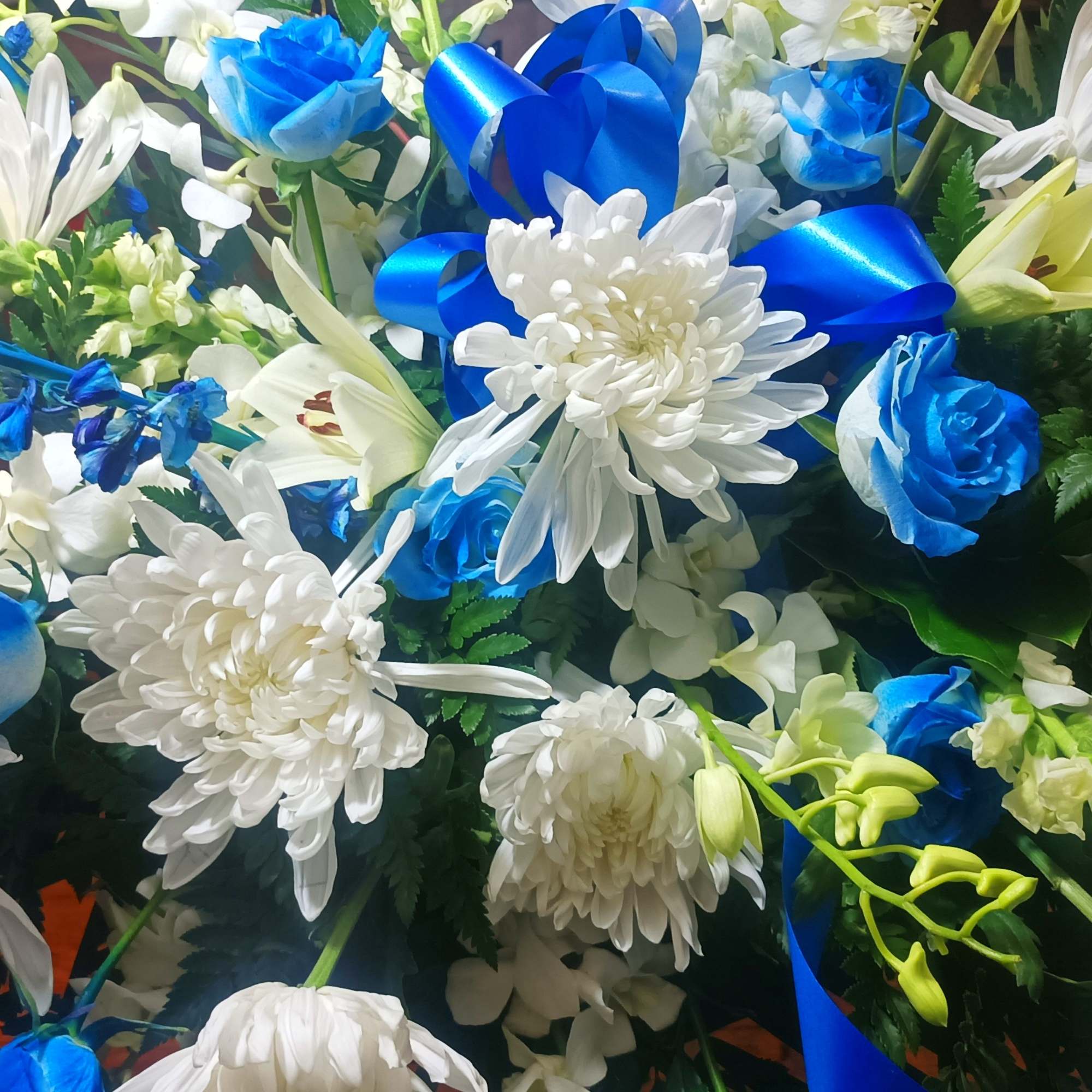 Blue and white floral arrangement with daisies and roses
