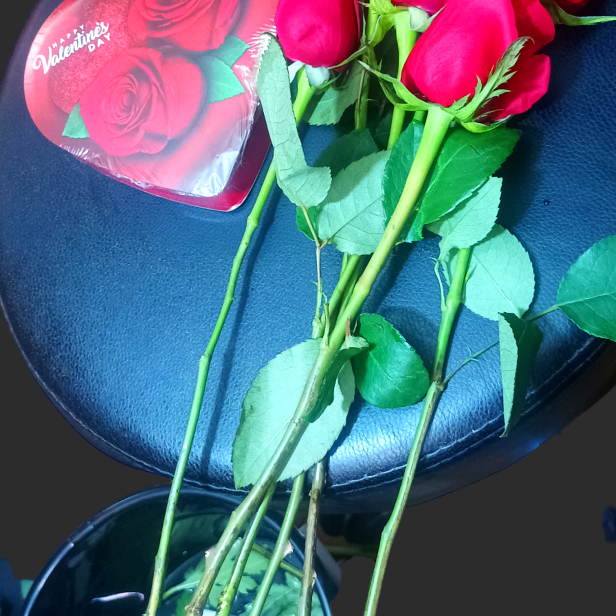 A bouquet of red roses with a Valentine heart card.