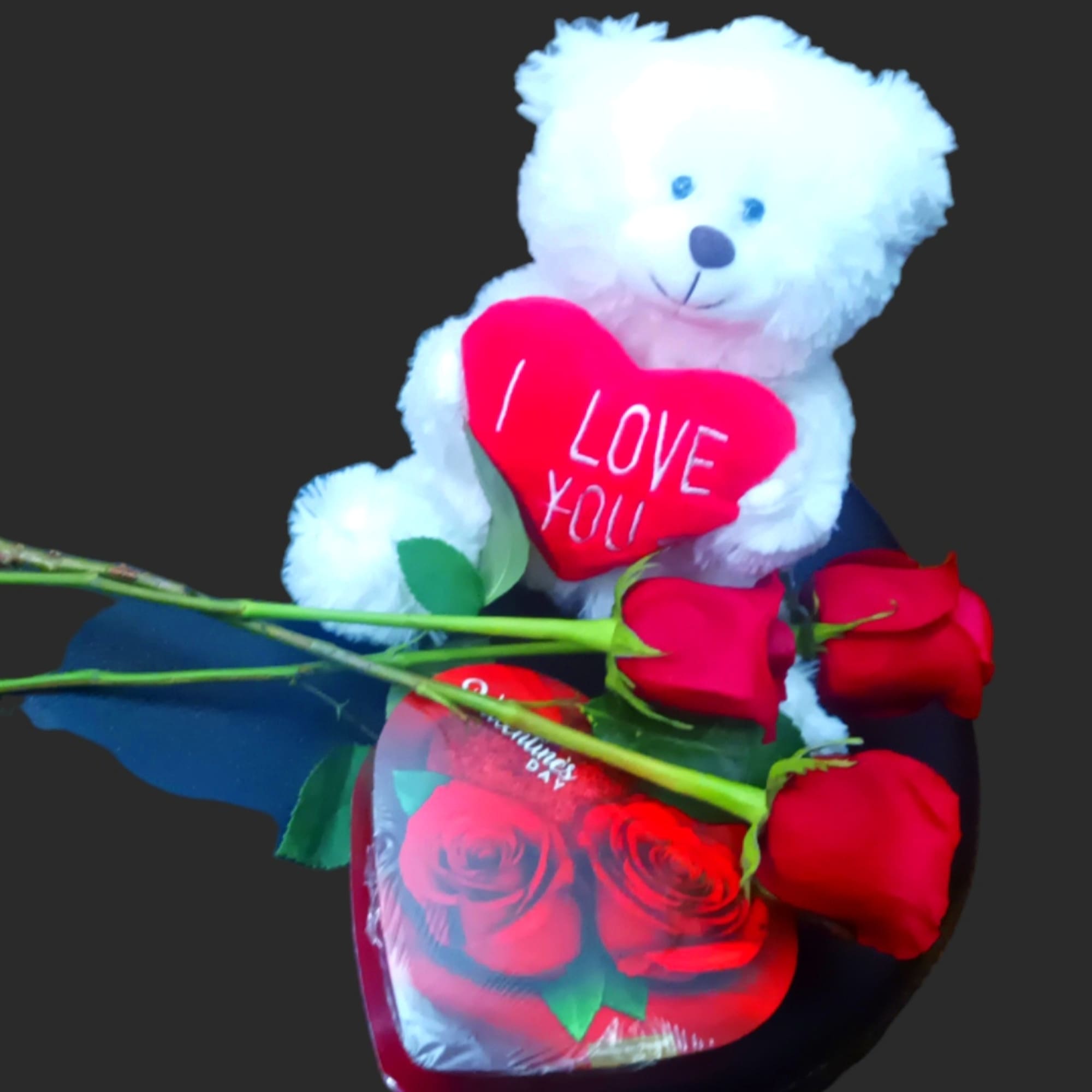 White teddy bear holding a red heart with red roses