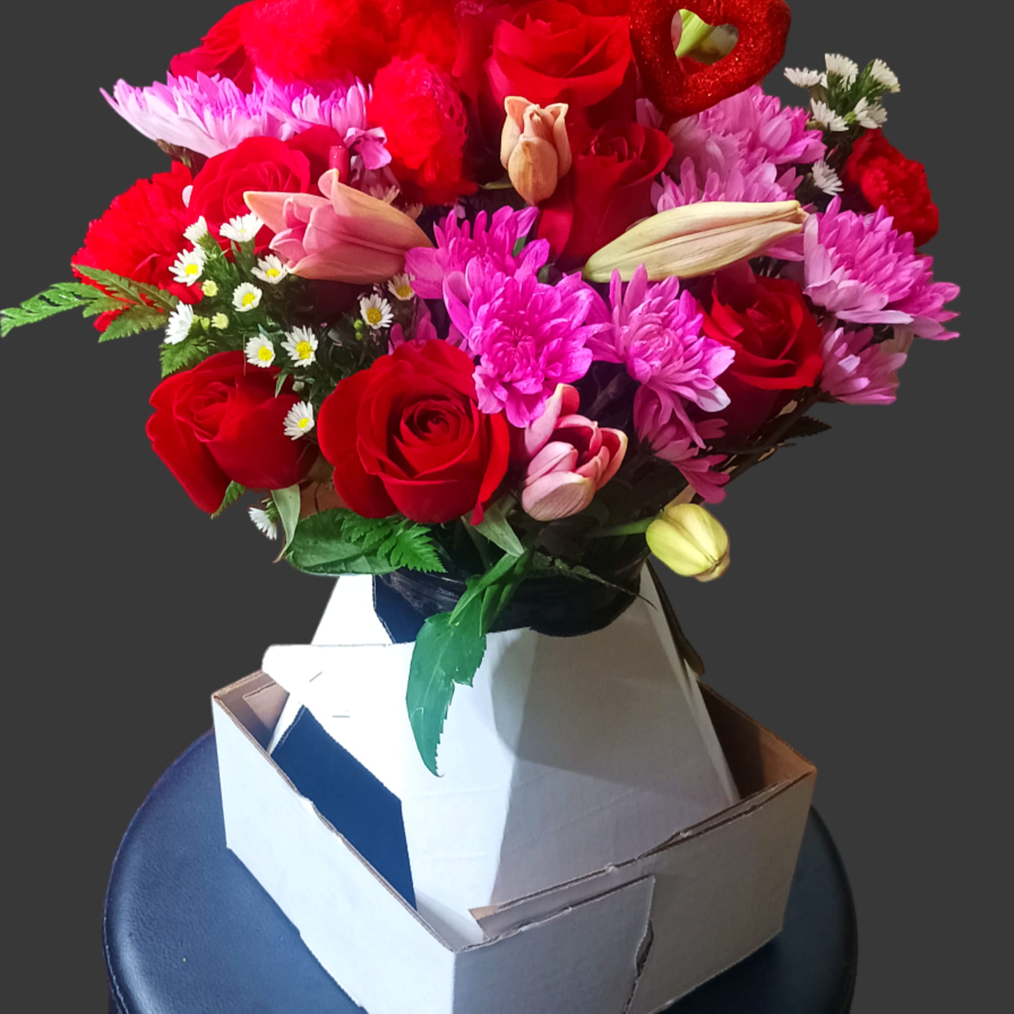 Red rose bouquet with pink flowers and a teddy bear topper in a box