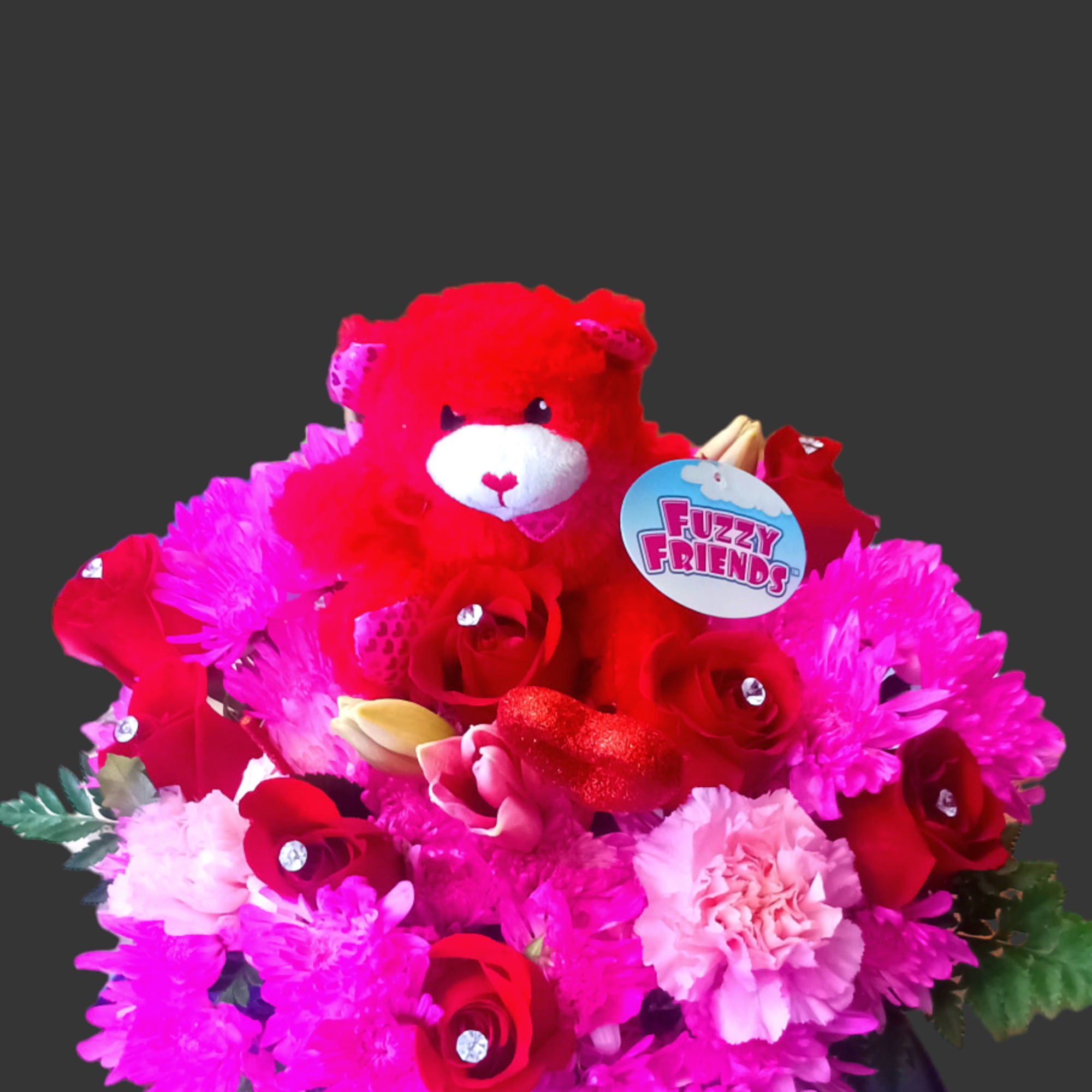 Red teddy bear surrounded by pink and red flowers in a round box
