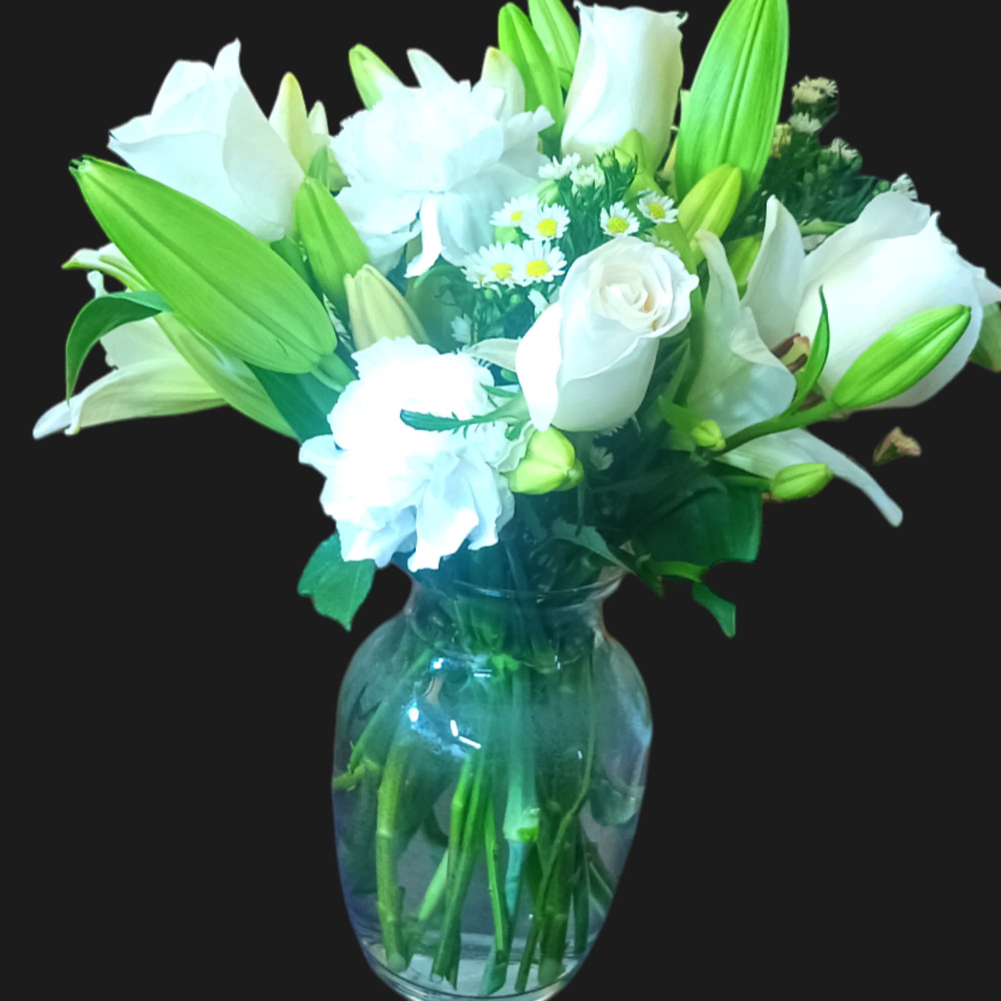 This arrangement includes white roses, white asiatic lilies, white and white carnations.
